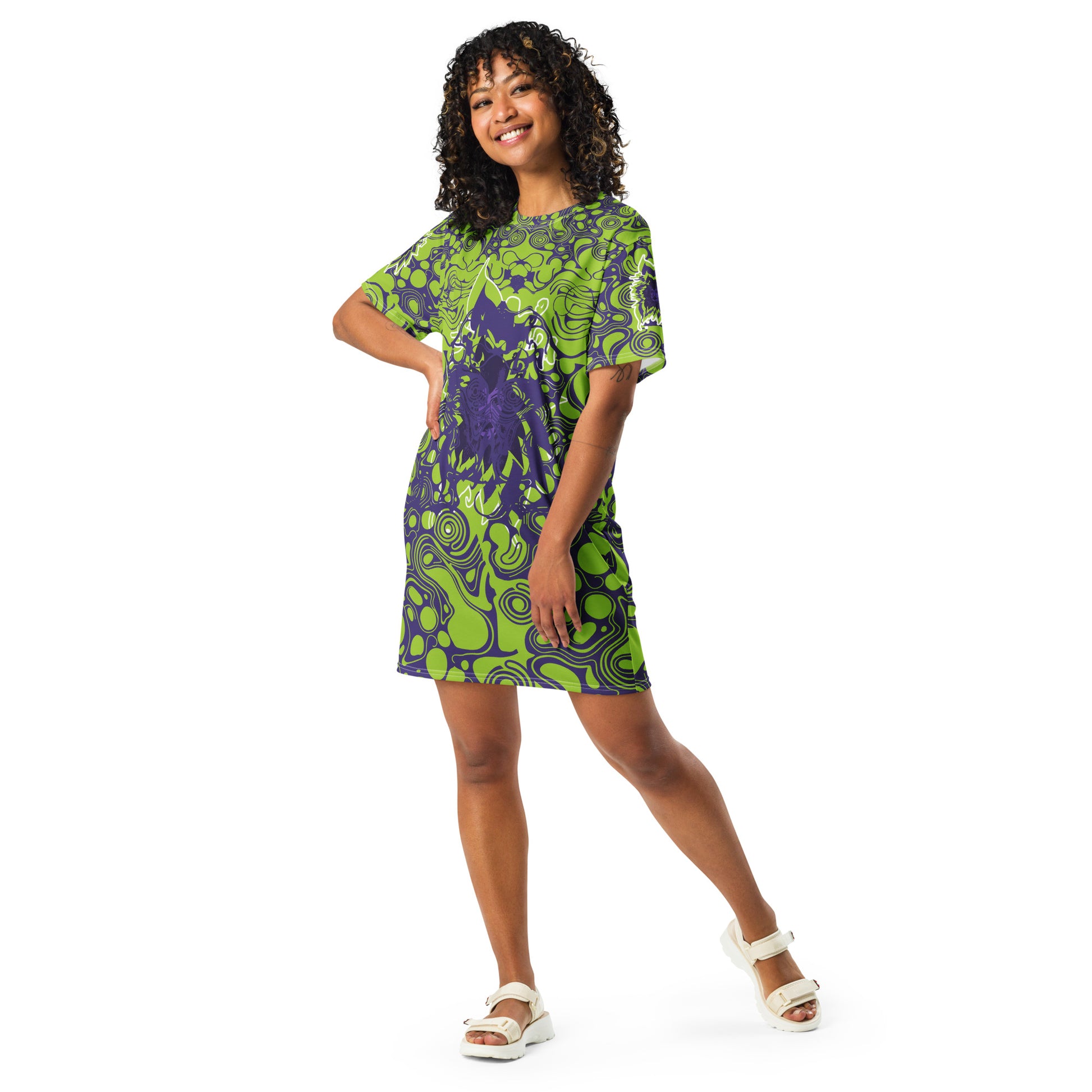 A model wearing green and purple t-shirt dress from Kloe Store featuring bold abstract patterns and a unique central artistic face design, perfect for a trendy and edgy streetwear style.