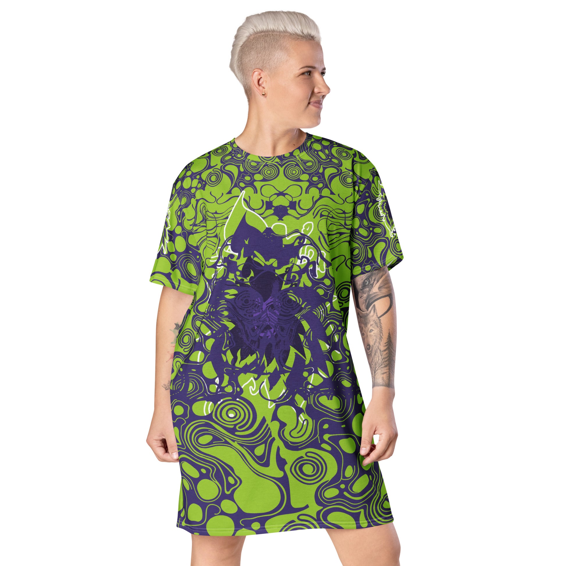 A model wearing green and purple t-shirt dress from Kloe Store featuring bold abstract patterns and a unique central artistic face design, perfect for a trendy and edgy streetwear style.