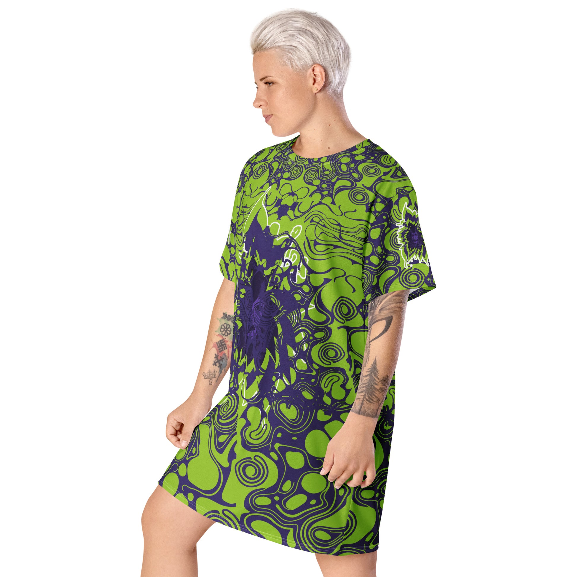 A model wearing green and purple t-shirt dress from Kloe Store featuring bold abstract patterns and a unique central artistic face design, perfect for a trendy and edgy streetwear style.