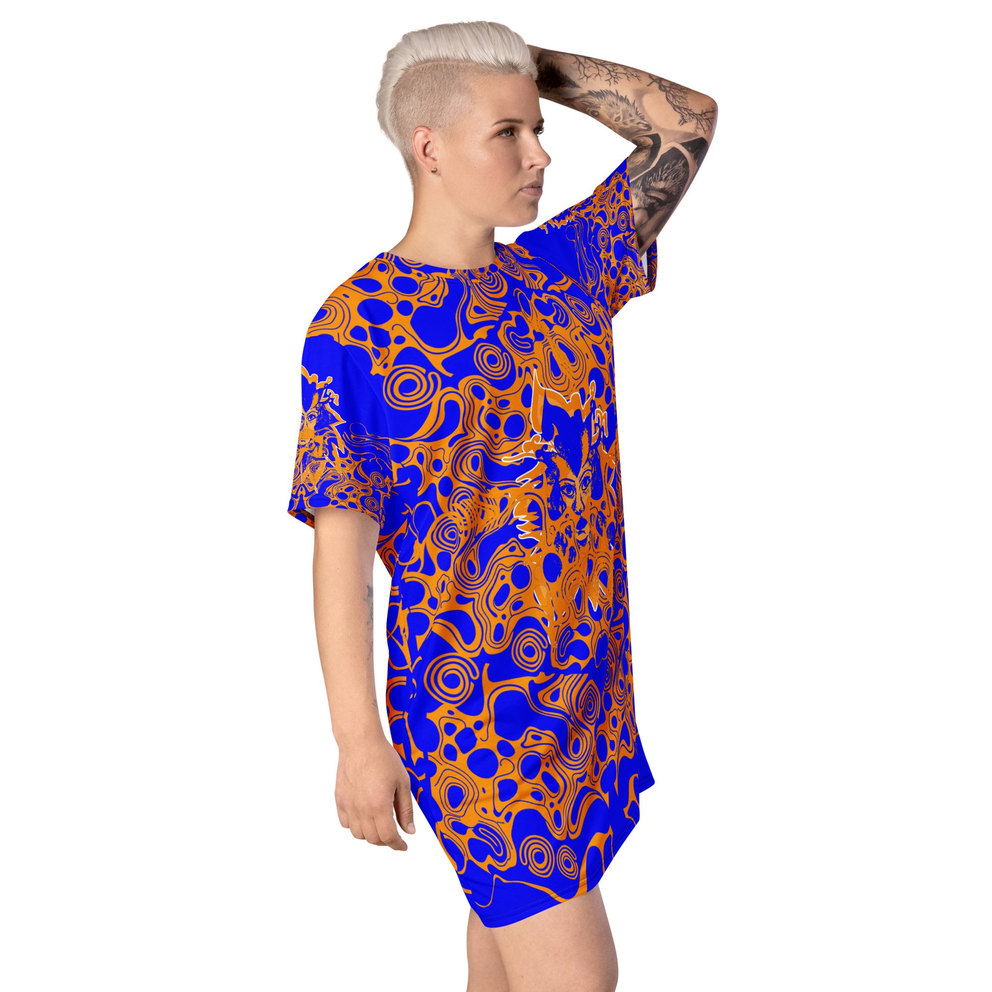 A model wearing bold blue and orange t-shirt dress from Kloe Store featuring intricate abstract patterns and a central artistic face design, offering a stylish and edgy streetwear look.