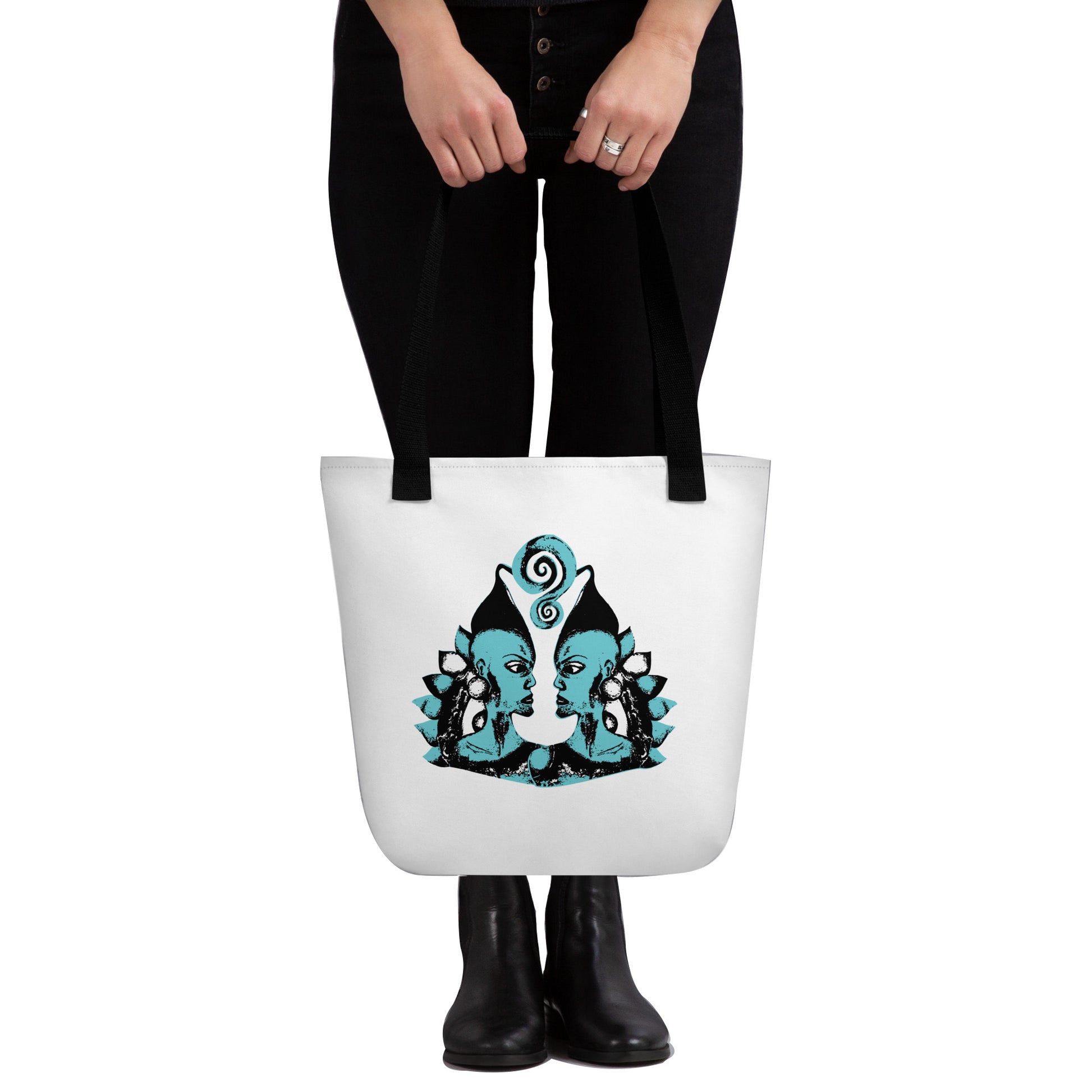 White tote bag with a bold K.L.O.E. hand-drawn design featuring two mirrored faces in black and teal, highlighting cultural inspiration, individuality, and modern bohemian self-expression.