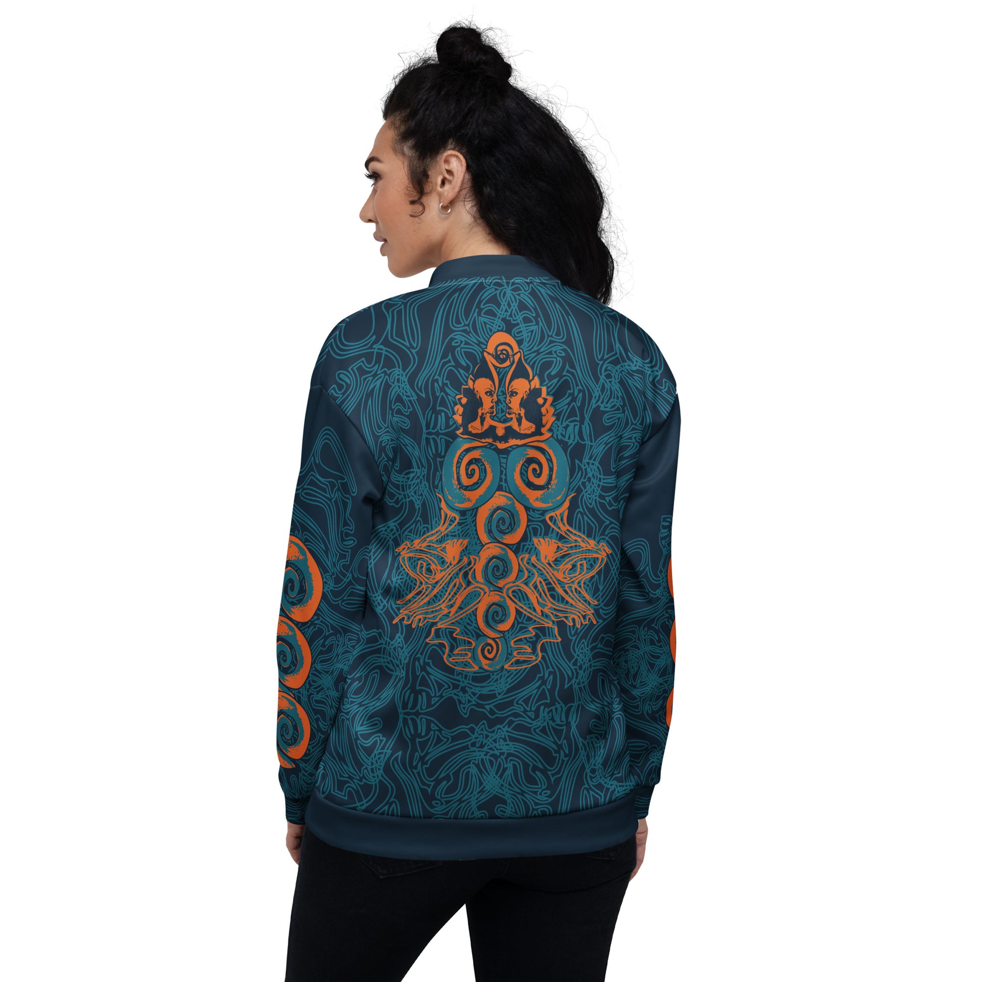 Back view of a navy blue bomber jacket featuring intricate cyan linework and bold orange mirrored face motifs, with swirling tribal-inspired patterns, on a model.