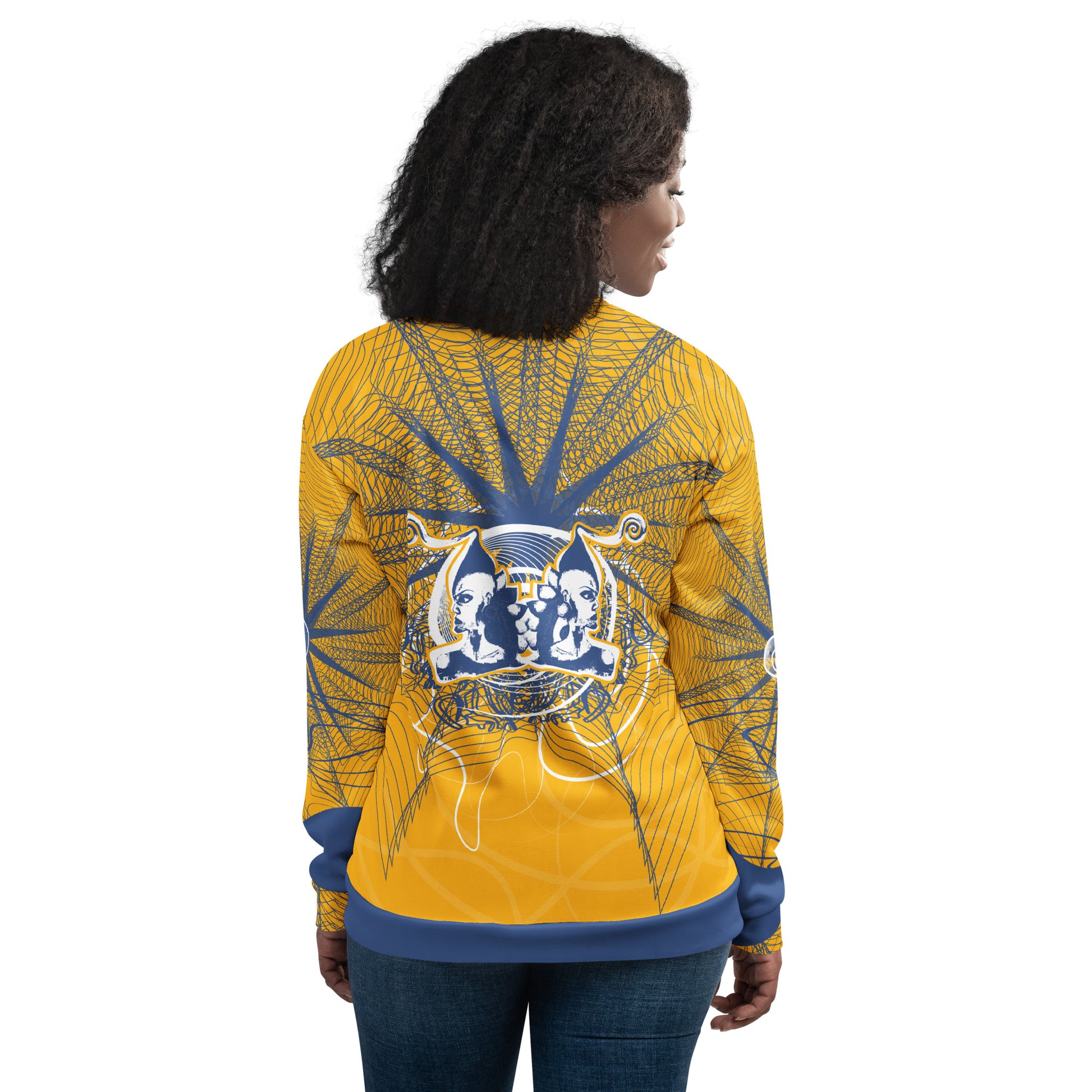 Back view of a golden yellow bomber jacket with intricate navy line art and a mirrored face emblem, combining bold cultural visuals with modern streetwear from the Secret Chambers of I and I collection.