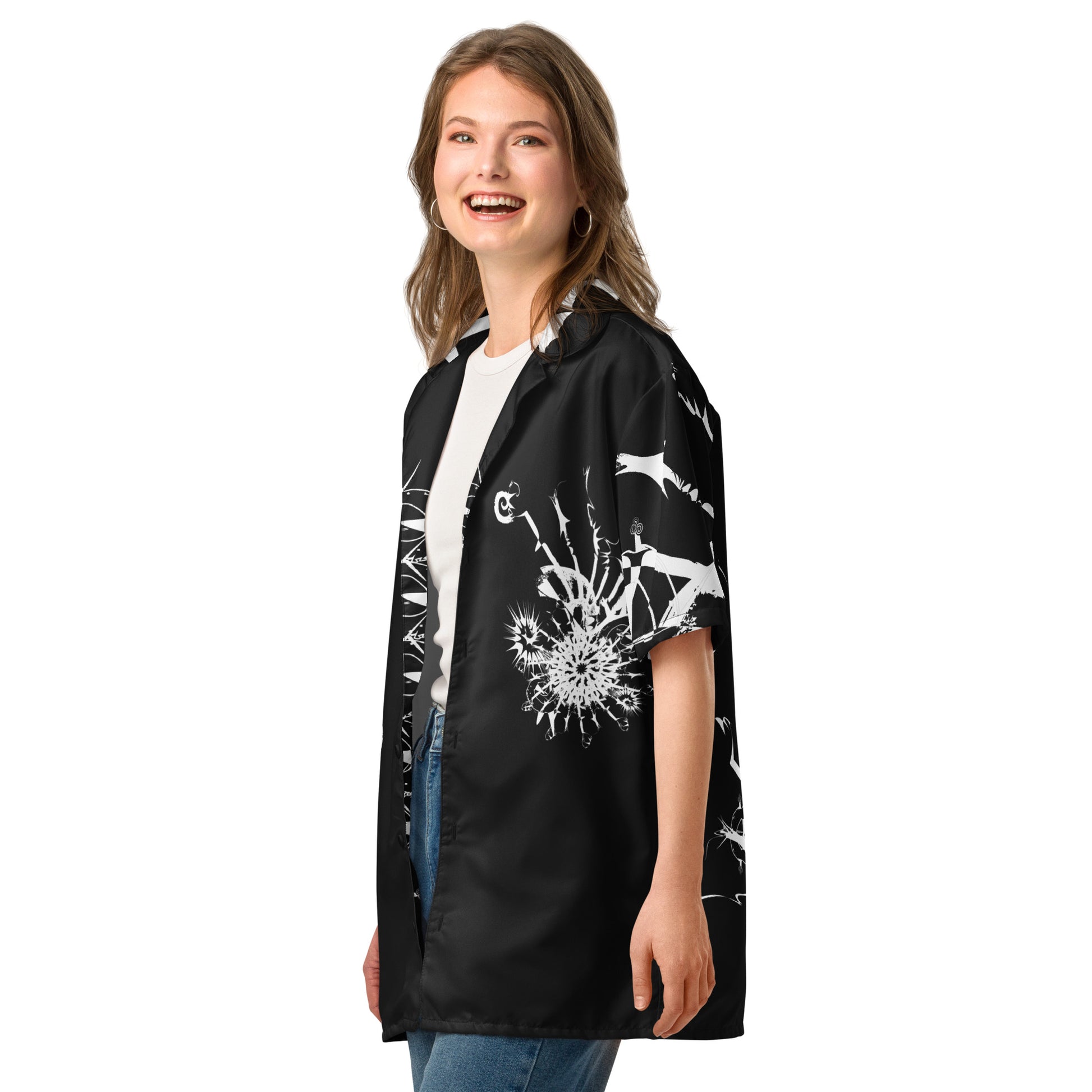 Side view of all-over print unisex button shirt by K.L.O.E featuring white hand-drawn, culturally inspired artwork across the front and sleeves—expressing individuality, transformation, and artistic symbolism through abstract design.