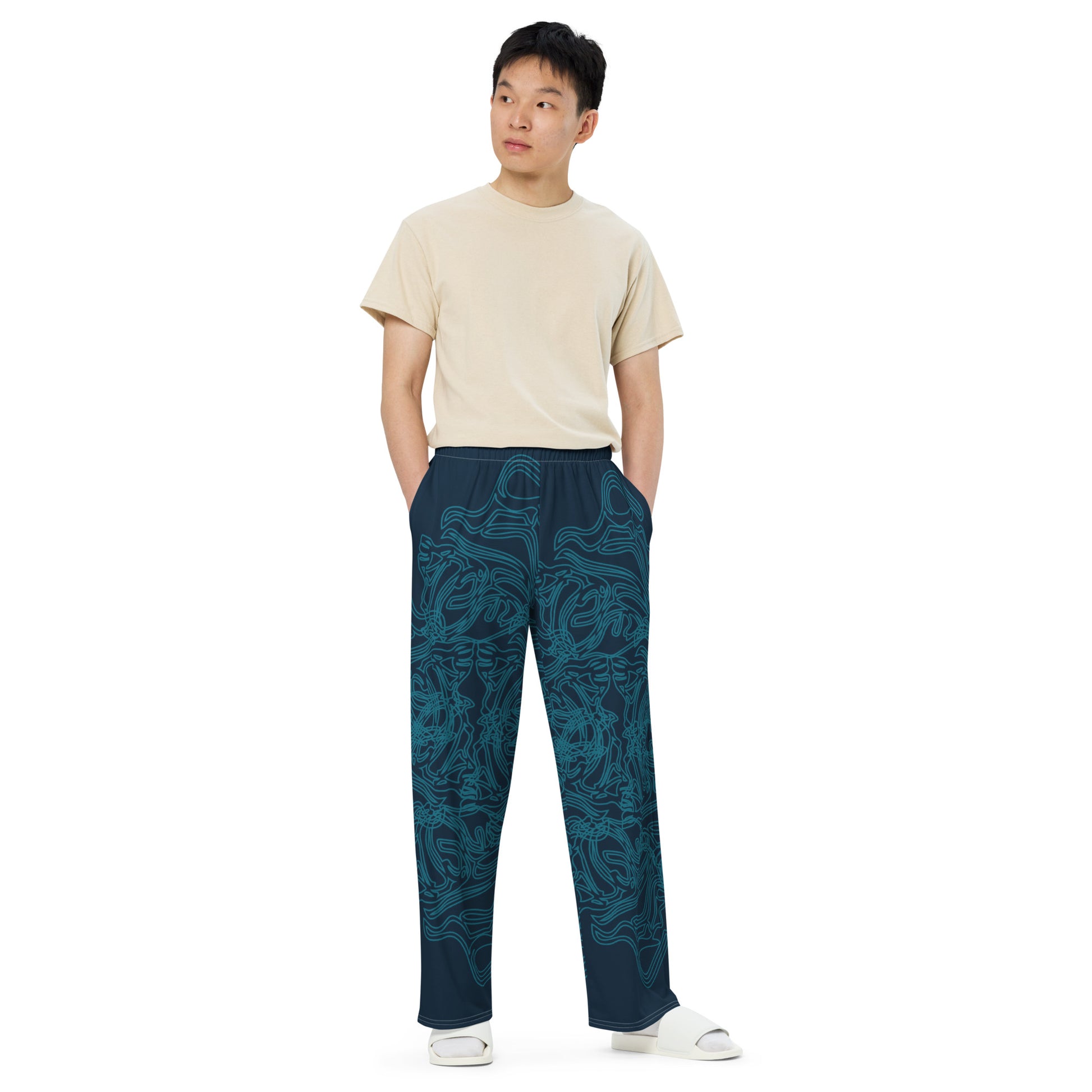 Navy blue wide-leg pants featuring intricate cyan linework, creating a fluid and artistic pattern for a bold statement look, on a model.