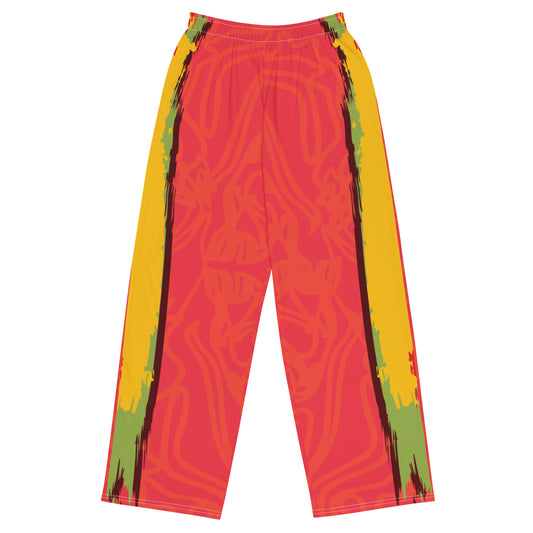 Wide-leg pants with a red base and abstract brushstroke side panels in yellow, green, and black, inspired by bold color play and cultural expression.