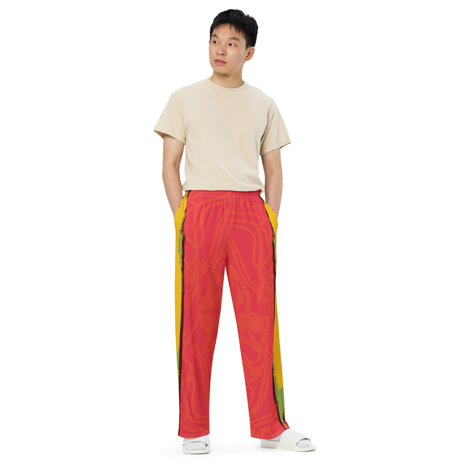 Wide-leg pants with a red base and abstract brushstroke side panels in yellow, green, and black, inspired by bold color play and cultural expression.