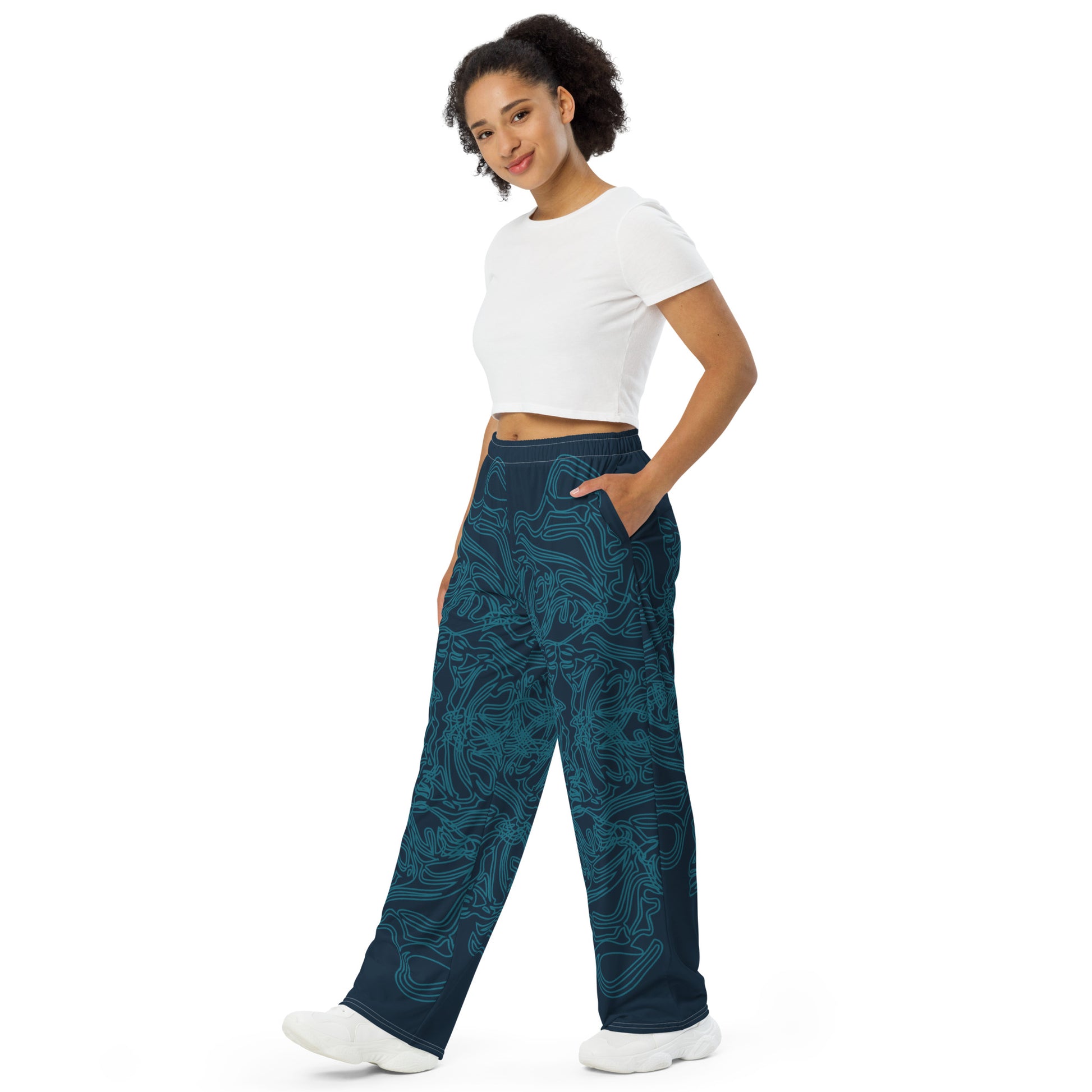 Navy blue wide-leg pants featuring intricate cyan linework, creating a fluid and artistic pattern for a bold statement look, on a model.