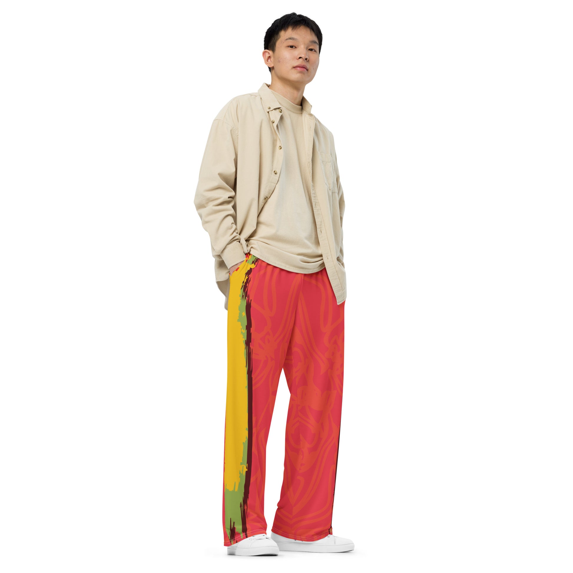 Wide-leg pants with a red base and abstract brushstroke side panels in yellow, green, and black, inspired by bold color play and cultural expression.