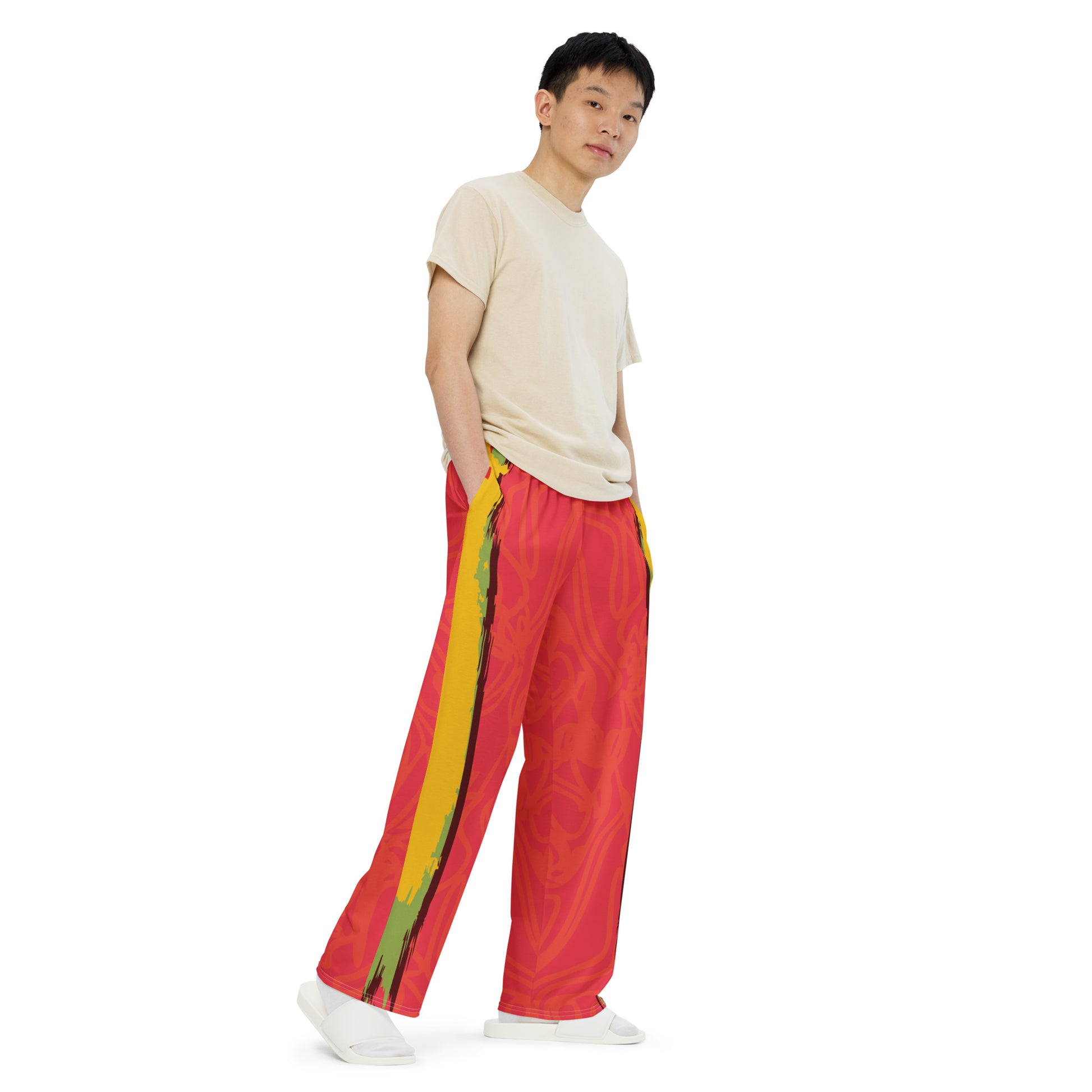 Wide-leg pants with a red base and abstract brushstroke side panels in yellow, green, and black, inspired by bold color play and cultural expression.