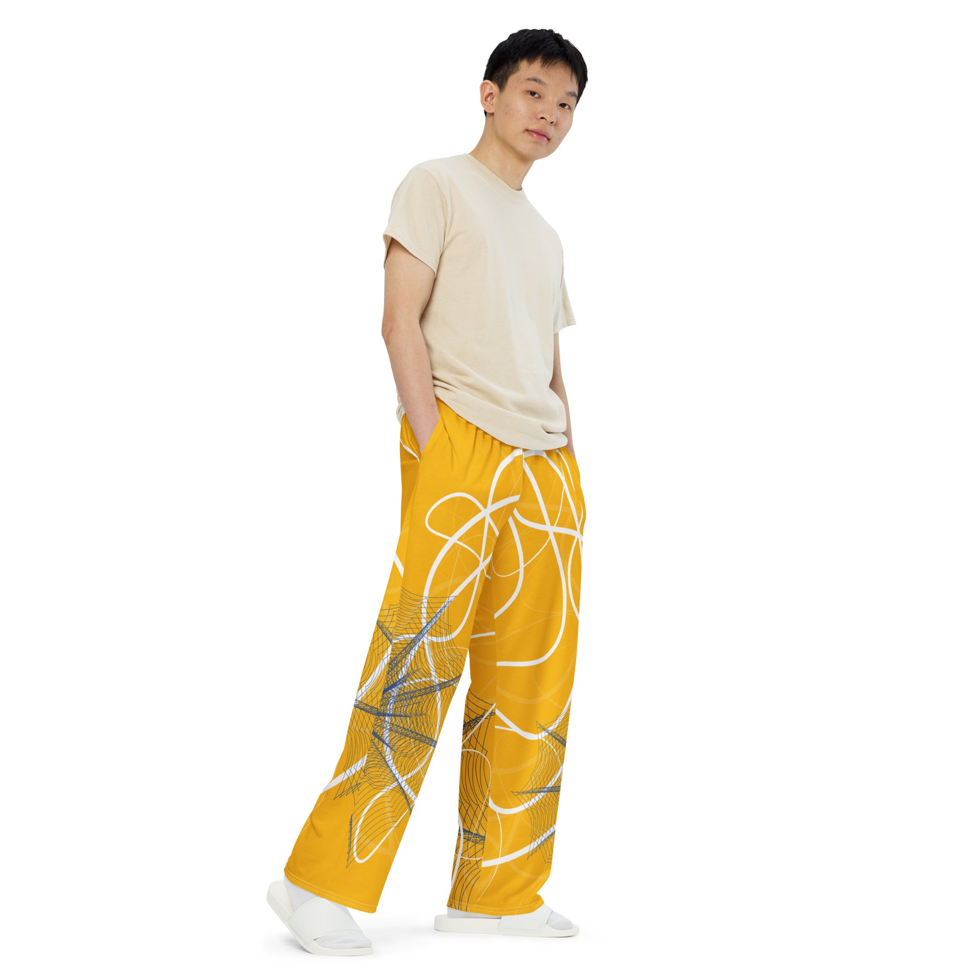 Golden yellow wide-leg pants featuring flowing white abstract line art and navy geometric patterns, merging expressive streetwear style with hand-drawn design from the Secret Chambers of I and I collection.