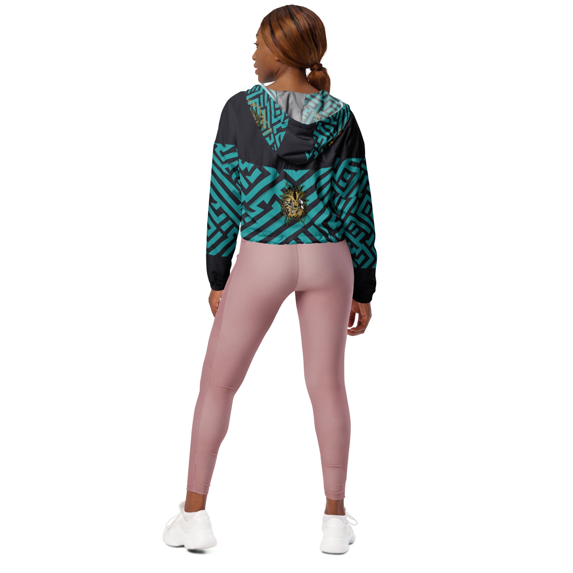 Confident woman wearing Kloe Store cropped windbreaker with bold green and black geometric patterns.