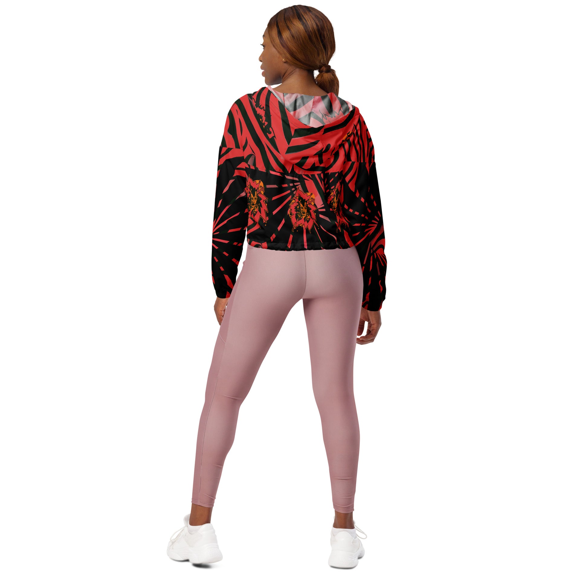 The model wearing red and black cropped women's windbreaker from Kloe Store featuring a bold swirling pattern, adjustable drawstring hem, and hood, showcasing trendy and stylish outerwear for modern street fashion, back view.