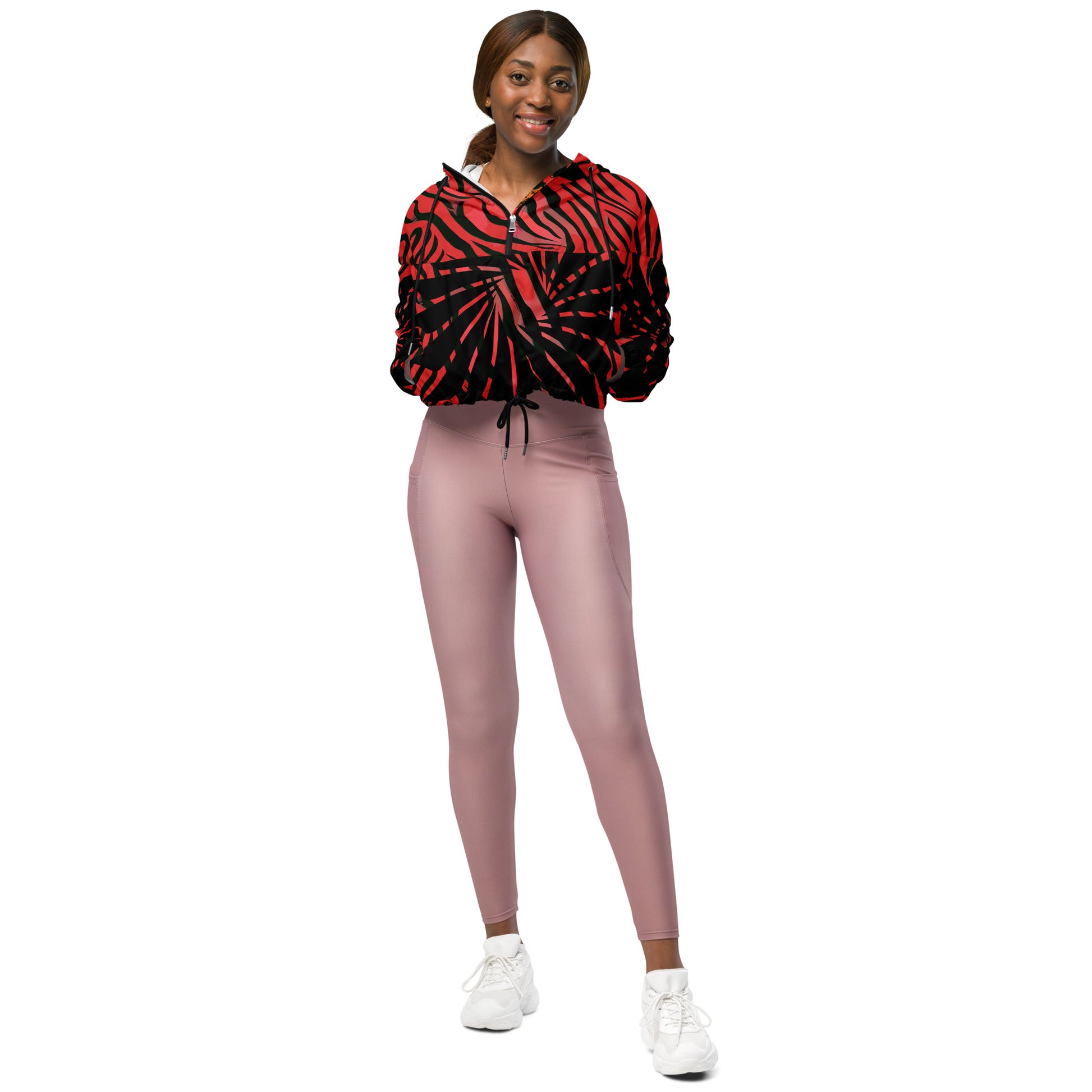 The model wearing red and black cropped women's windbreaker from Kloe Store featuring a bold swirling pattern, adjustable drawstring hem, and hood, showcasing trendy and stylish outerwear for modern street fashion.