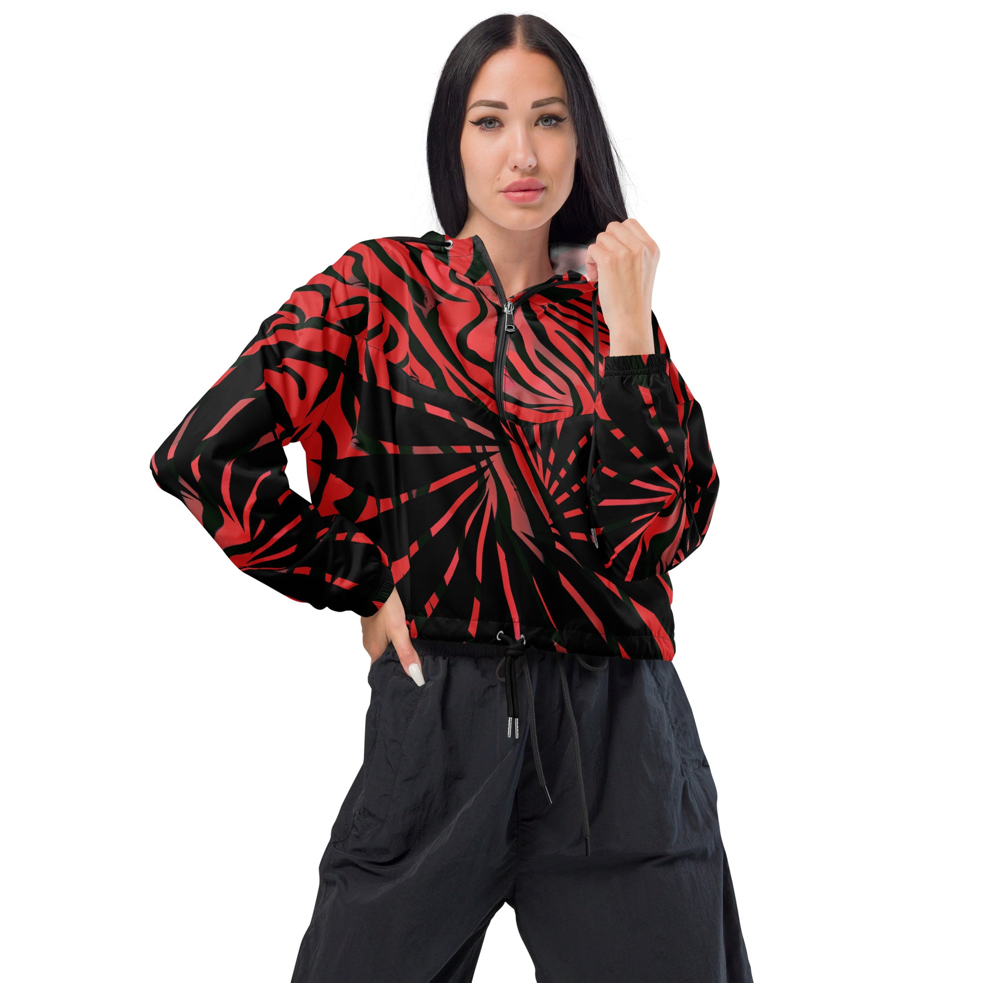 The model wearing red and black cropped women's windbreaker from Kloe Store featuring a bold swirling pattern, adjustable drawstring hem, and hood, showcasing trendy and stylish outerwear for modern street fashion, front view.