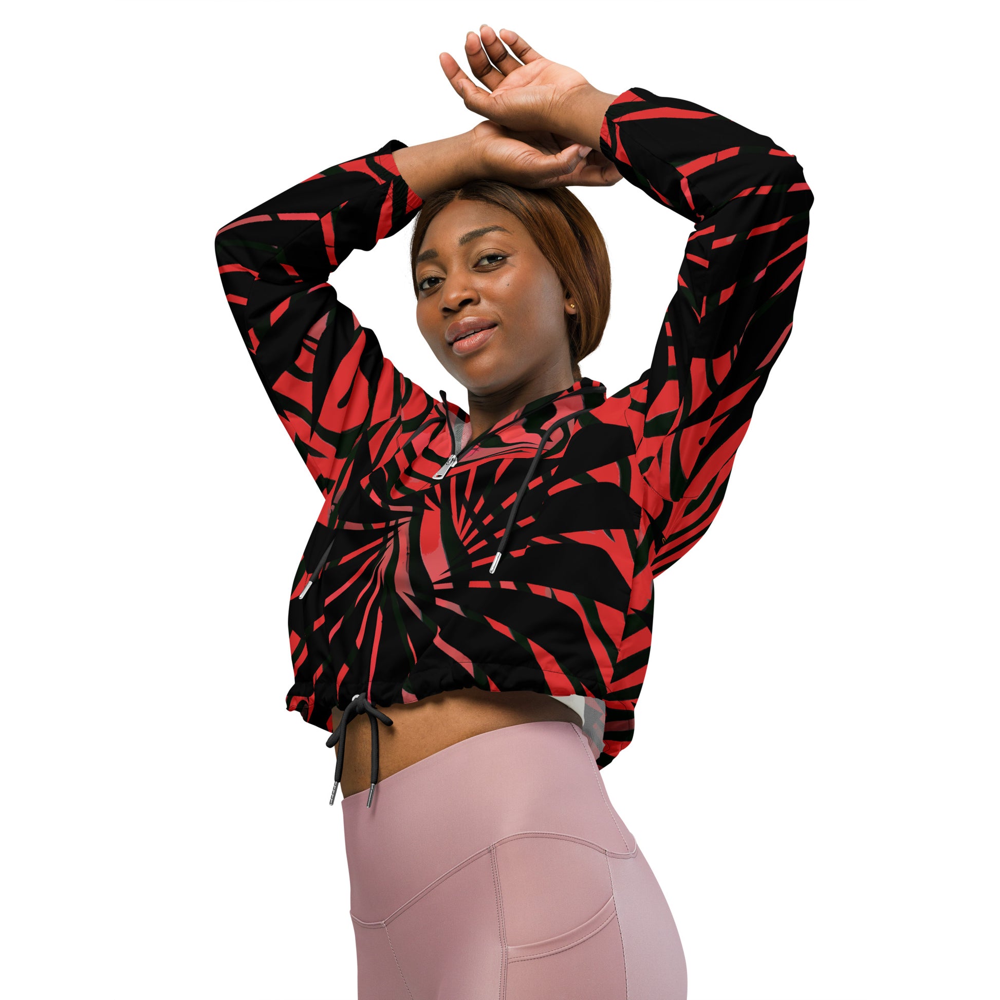 The model wearing red and black cropped women's windbreaker from Kloe Store featuring a bold swirling pattern, adjustable drawstring hem, and hood, showcasing trendy and stylish outerwear for modern street fashion.