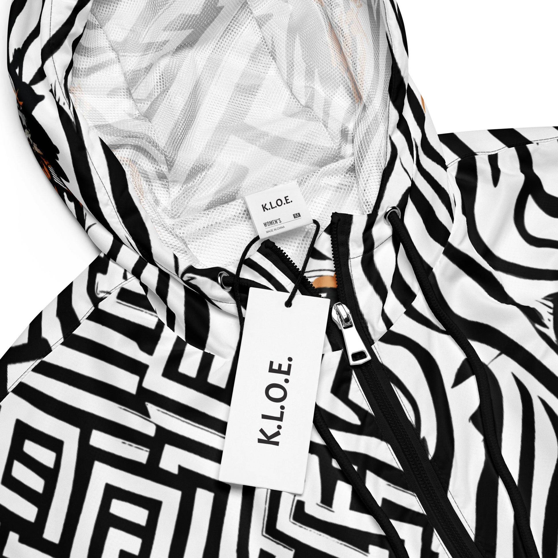 The model wearing black and white zebra print cropped windbreaker from Kloe Store featuring bold geometric patterns and an artistic face design, perfect for trendy streetwear fashion with an edgy, modern look, showing the product details.