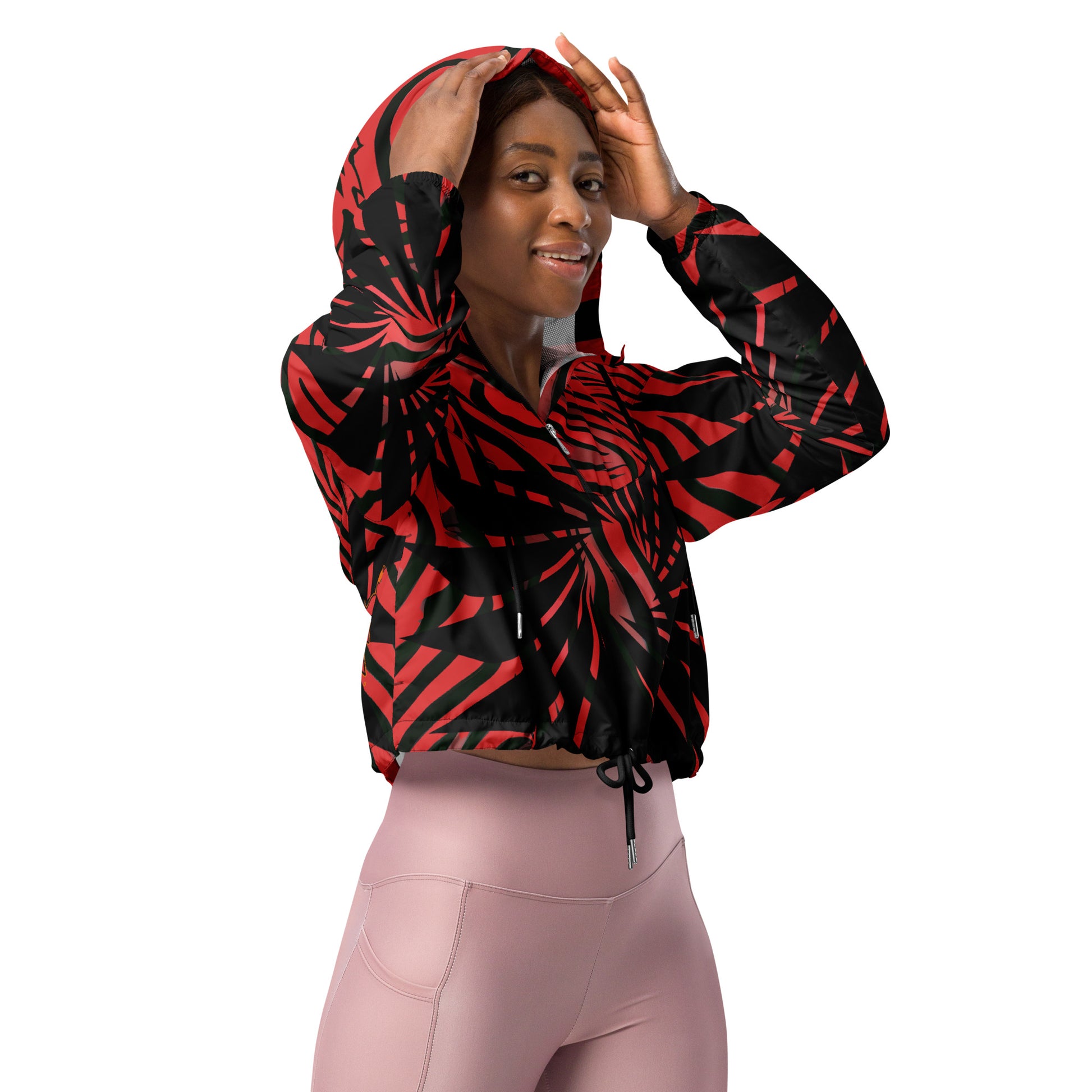 The model wearing red and black cropped women's windbreaker from Kloe Store featuring a bold swirling pattern, adjustable drawstring hem, and hood, showcasing trendy and stylish outerwear for modern street fashion.