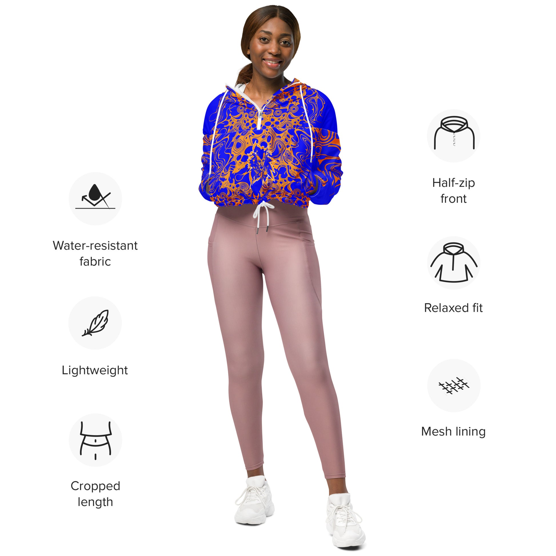 Product mockup - model wearing a vibrant blue and orange cropped windbreaker from Kloe Store featuring abstract swirl pattern, a front zipper, drawstring hood, and elastic cuffs, offering a stylish and modern streetwear look.