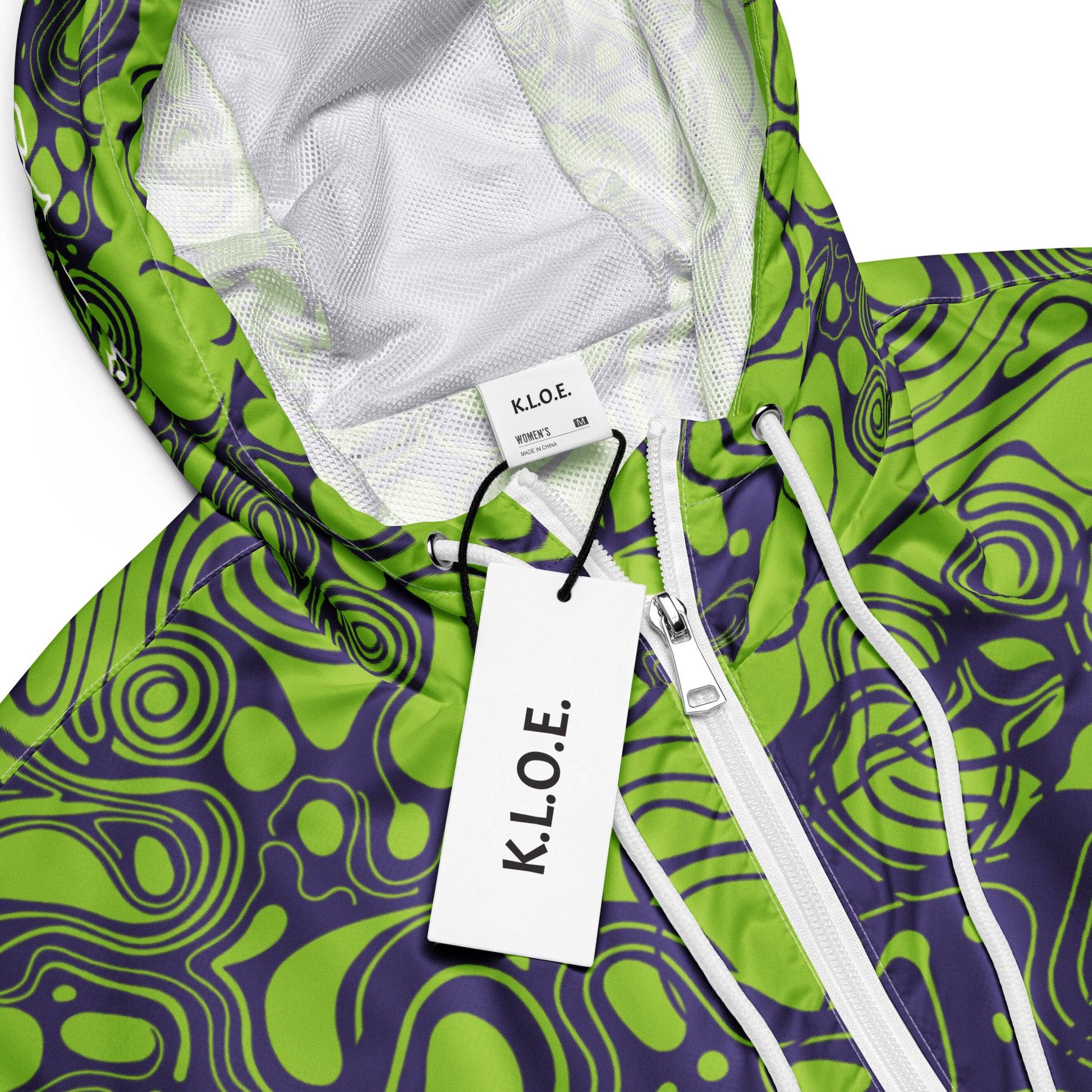 The model wearing green and purple cropped windbreaker from Kloe Store featuring bold abstract patterns and a unique artistic face design, ideal for a trendy streetwear look, detail view.
