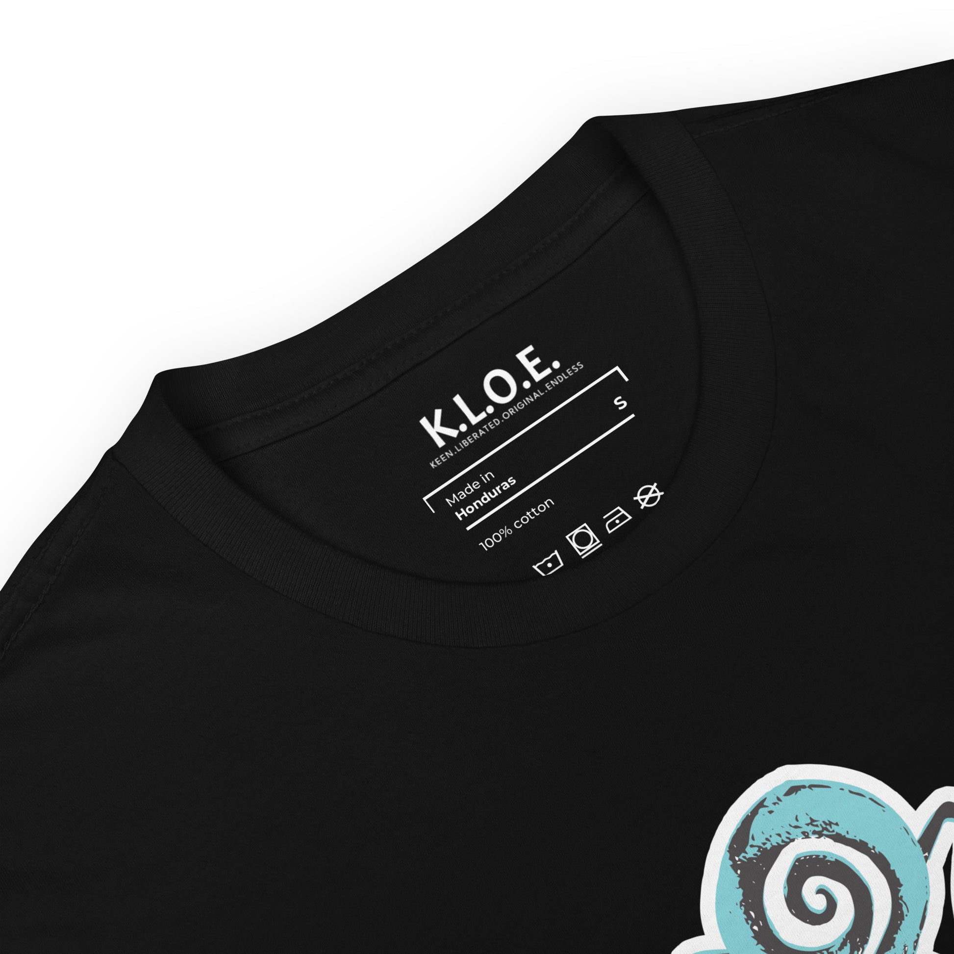 A model wearing black K.L.O.E. t-shirt showcasing a hand-drawn design of two mirrored faces in black and teal, embodying culturally inspired, bohemian style fashion focused on individuality and artistic expression, detailed view showing the inside label.
