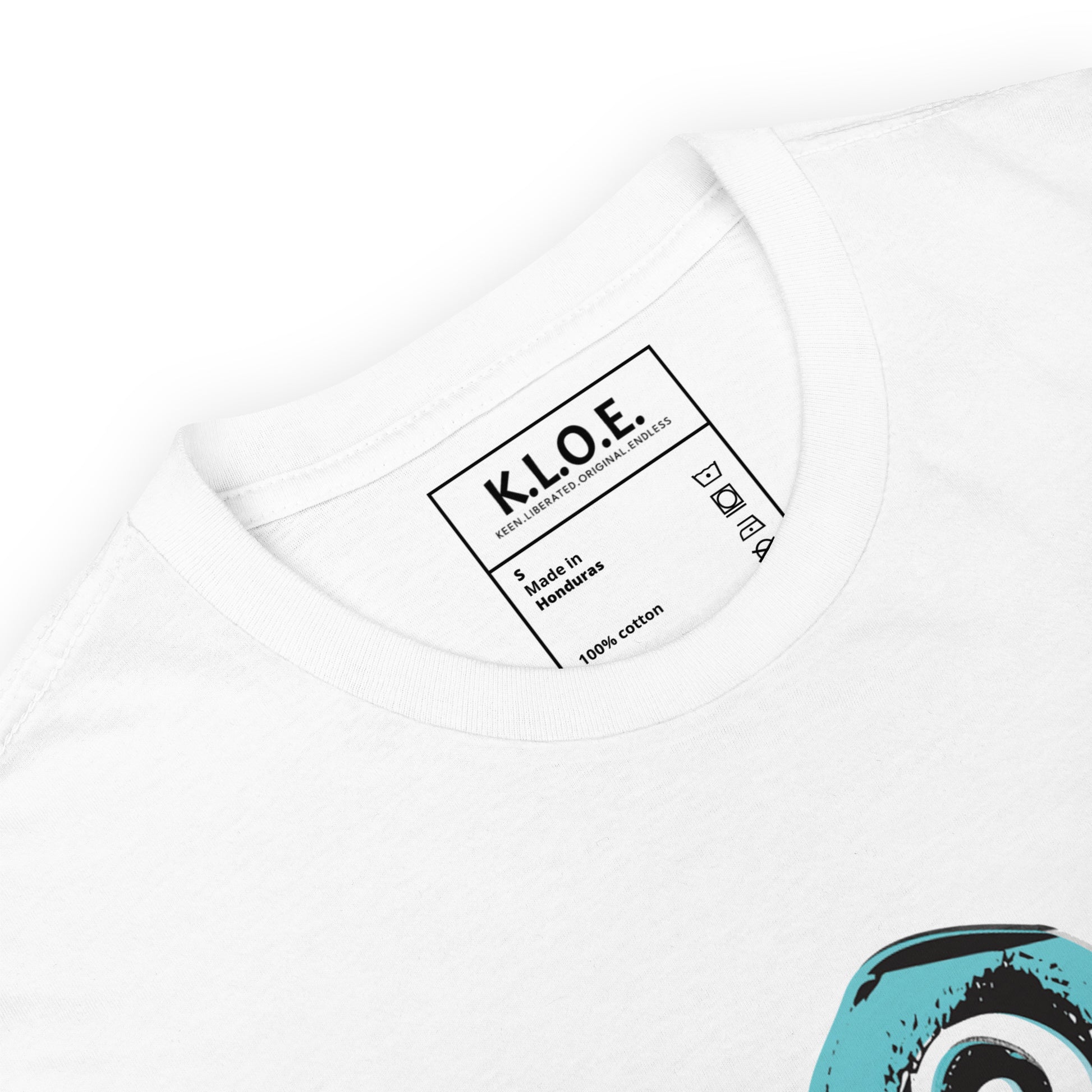 A detailed view of white K.L.O.E. t-shirt featuring a culturally inspired, hand-drawn design of two mirrored faces with bold, artistic details in black and teal, symbolizing self-expression and individuality in bohemian style clothing, inside label view.