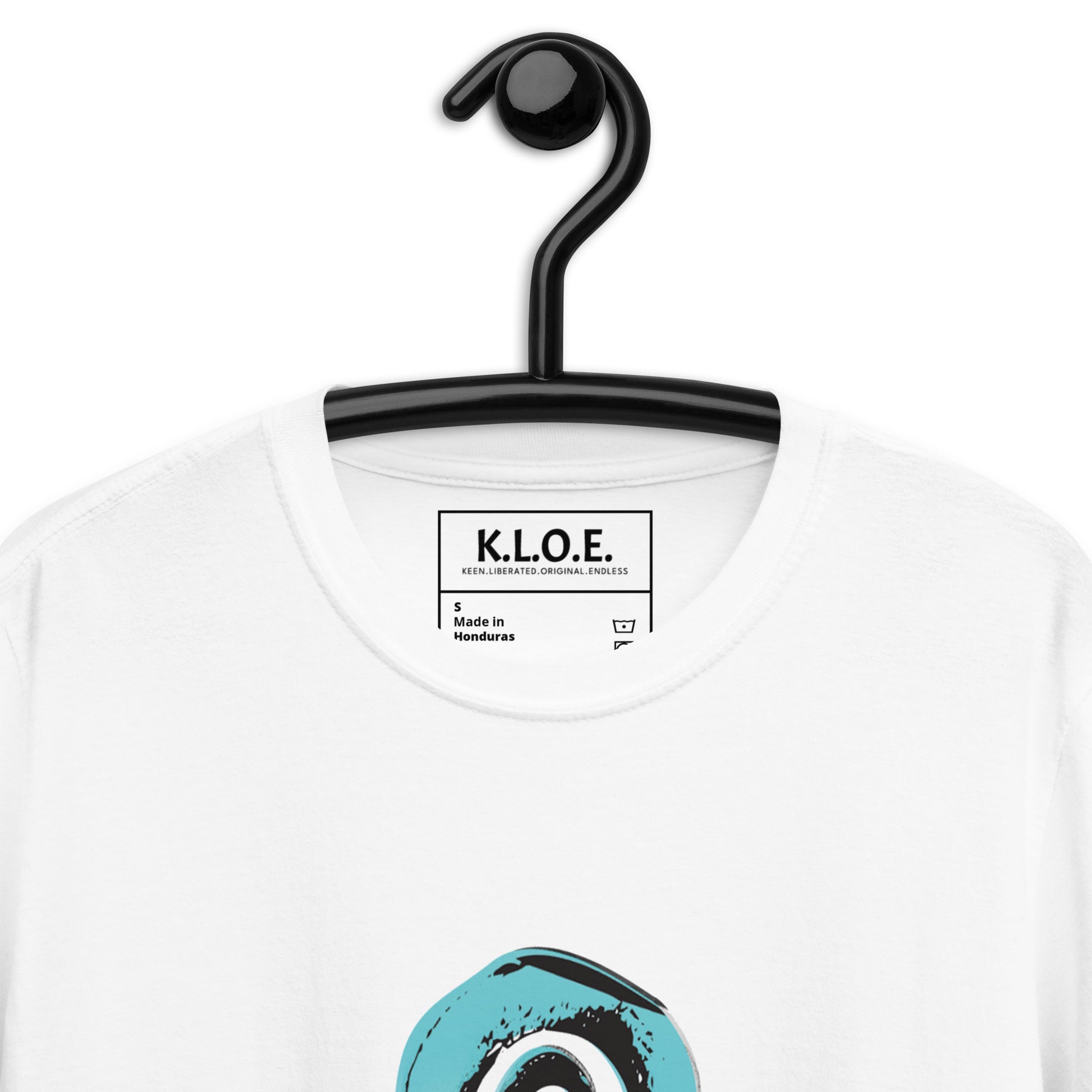 A detailed view of white K.L.O.E. t-shirt featuring a culturally inspired, hand-drawn design of two mirrored faces with bold, artistic details in black and teal, symbolizing self-expression and individuality in bohemian style clothing, inside label view.