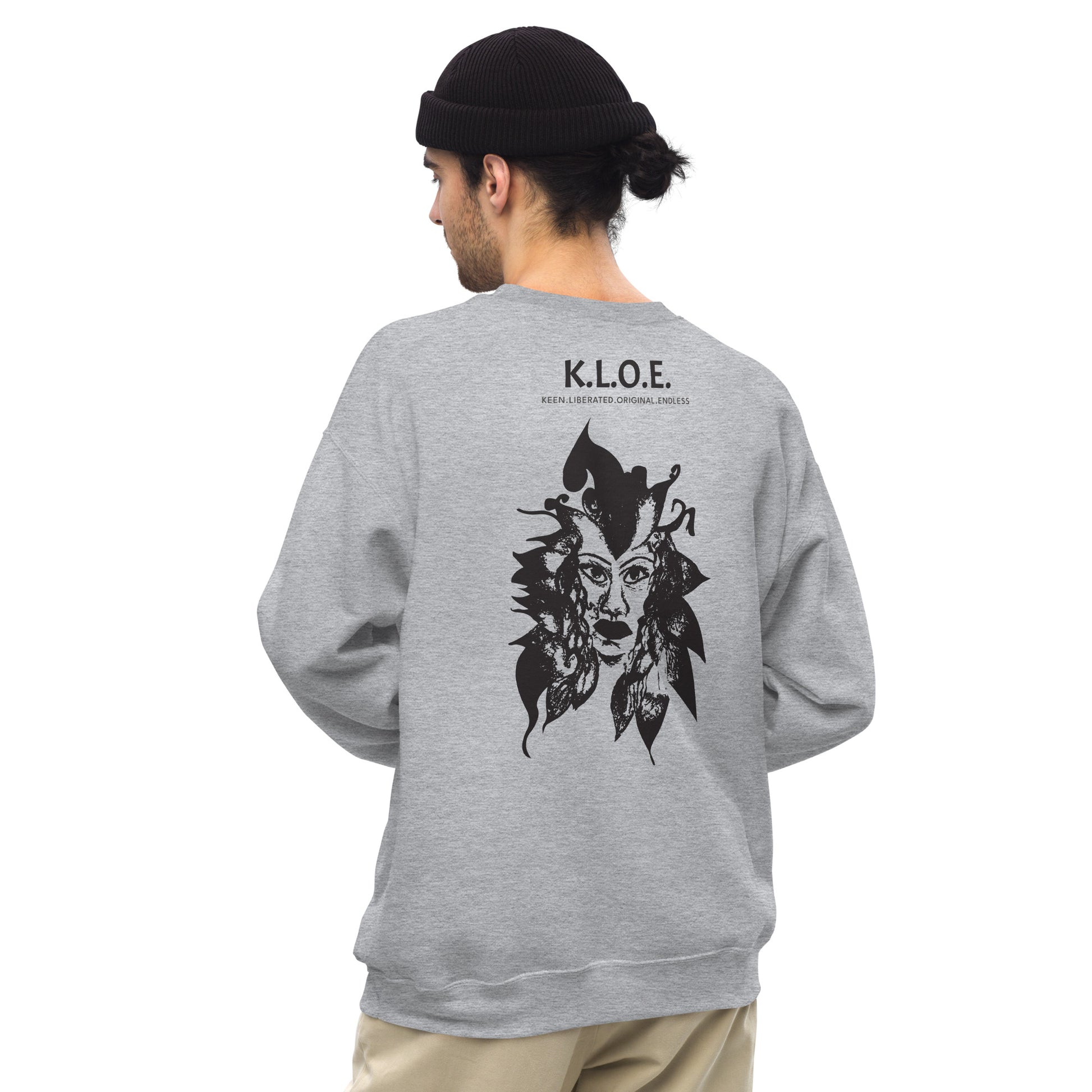 Back view of a grey K.L.O.E. sweatshirt showcasing a culturally inspired, hand-drawn black design featuring a bold, expressive face intertwined with flowing, abstract patterns, and K.L.O.E. logo, embodying artistic self-expression and modern bohemian style fashion, on a model.