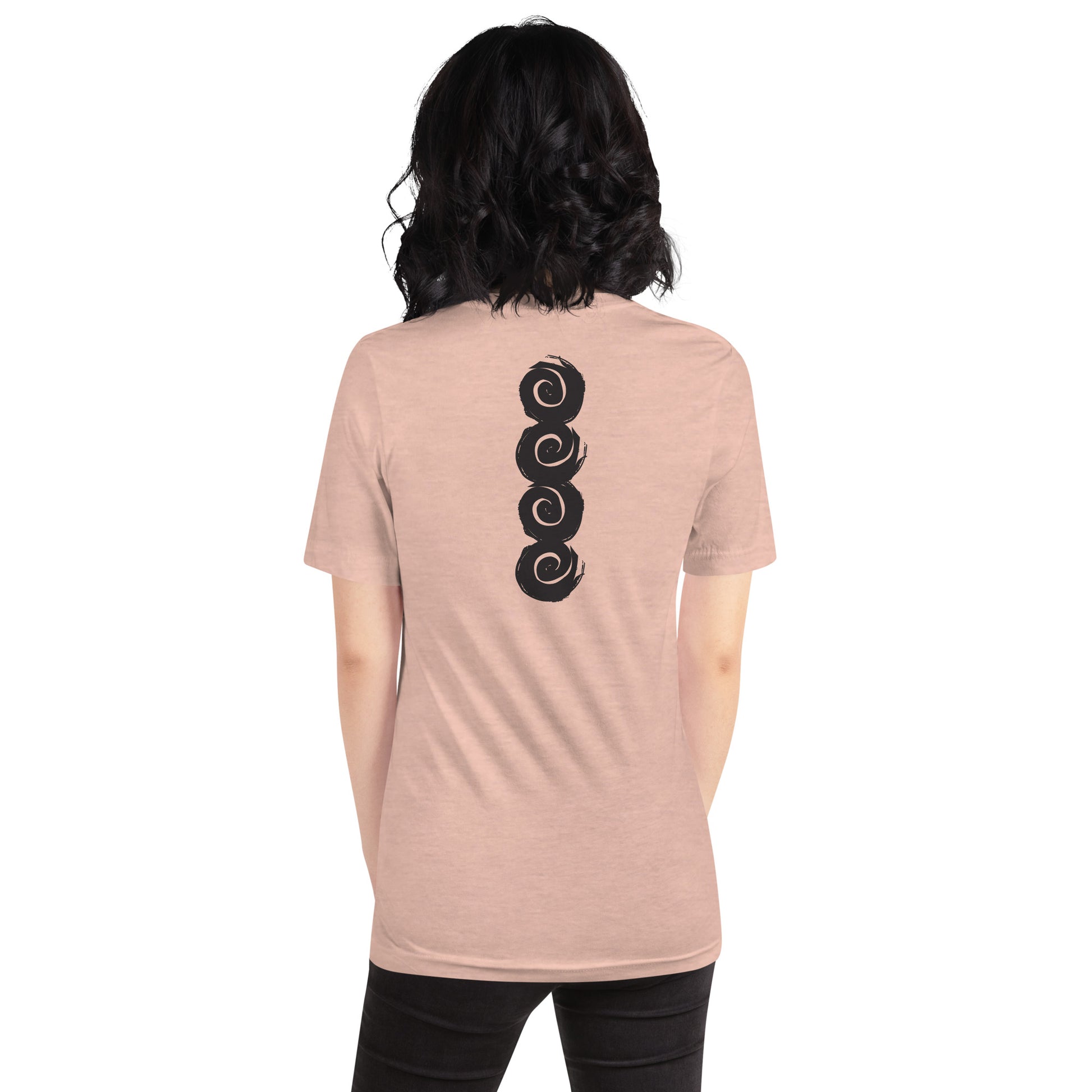 Back of an peach color t-shirt featuring a vertical row of four bold, black spiral symbols, hand-drawn in an expressive, brushstroke style. This culturally inspired design from K.L.O.E. highlights artisan craftsmanship and modern boho style, perfect for those who seek unique, eco-friendly fashion and artistic self-expression, worn by a model.