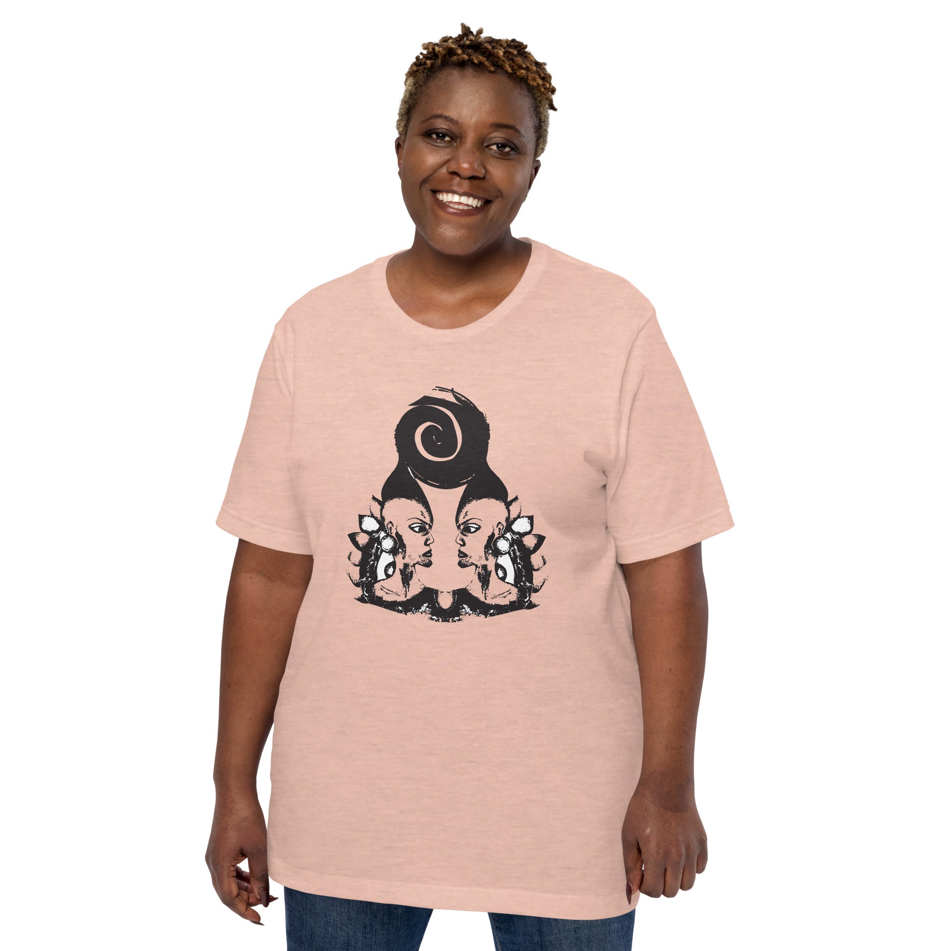 A plus size model wearing peach color t-shirt featuring a hand-drawn black ink design of two mirrored female figures with bold, intricate headpieces, connected by a swirling central element. This artistic piece from K.L.O.E. embraces cultural inspiration and self-expression, crafted for those who appreciate unique, expressive fashion and modern bohemian style. 