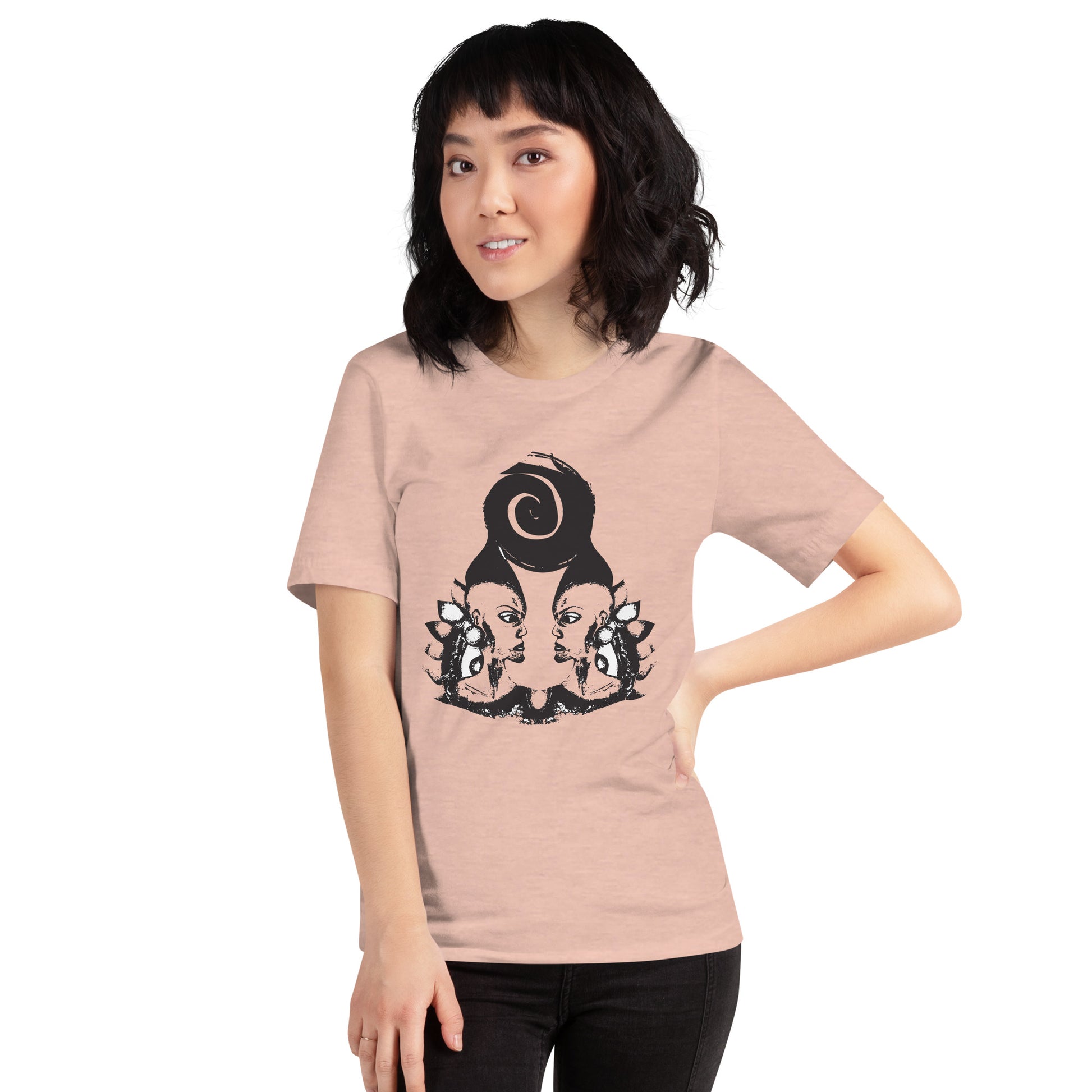 A model wearing peach color t-shirt featuring wearable illustrations with an art-inspired black design of mirrored female faces and a bold central spiral symbol, celebrating expressive fashion and individuality – unique clothing by K.L.O.E.