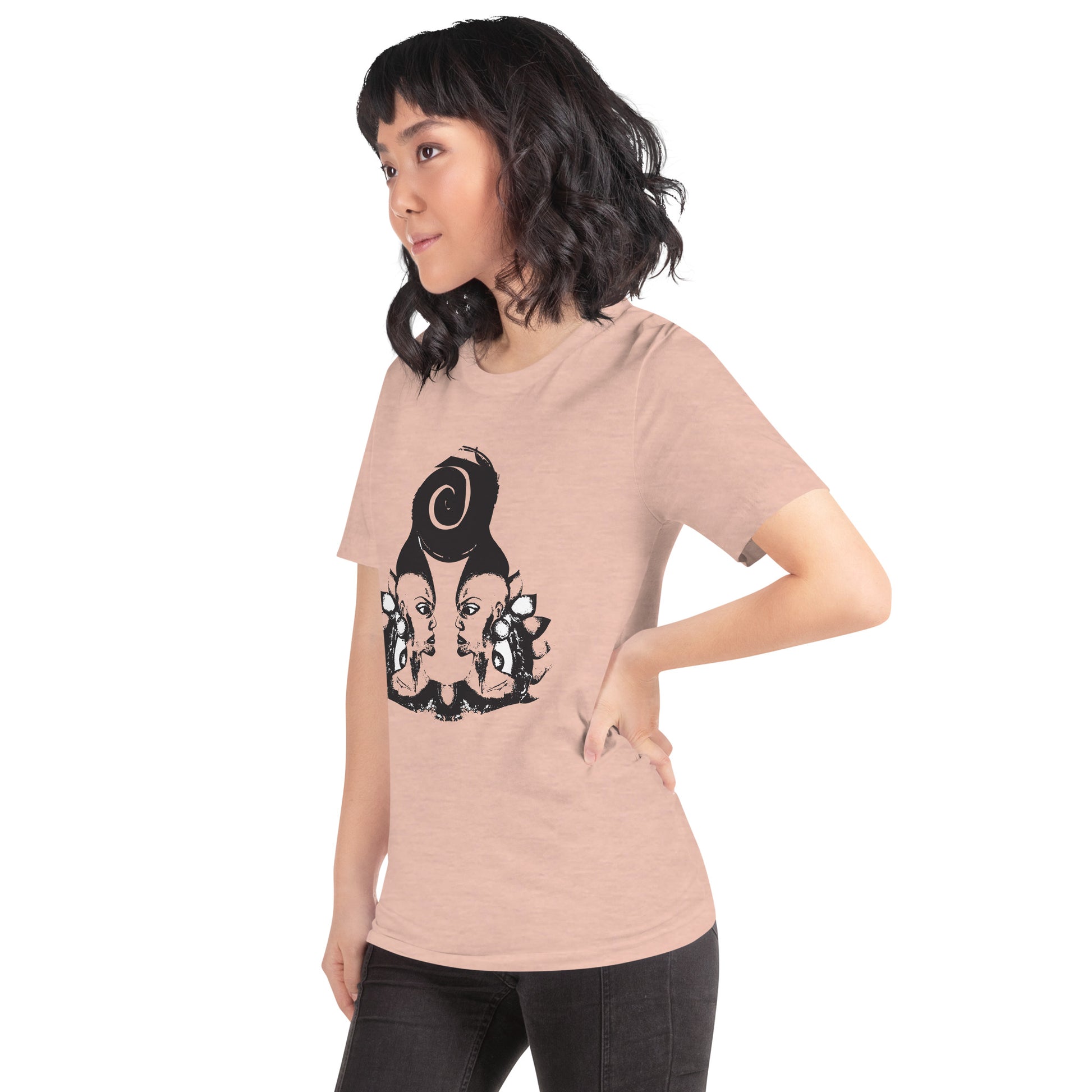 A model wearing peach color t-shirt featuring wearable illustrations with an art-inspired black design of mirrored female faces and a bold central spiral symbol, celebrating expressive fashion and individuality – unique clothing by K.L.O.E.