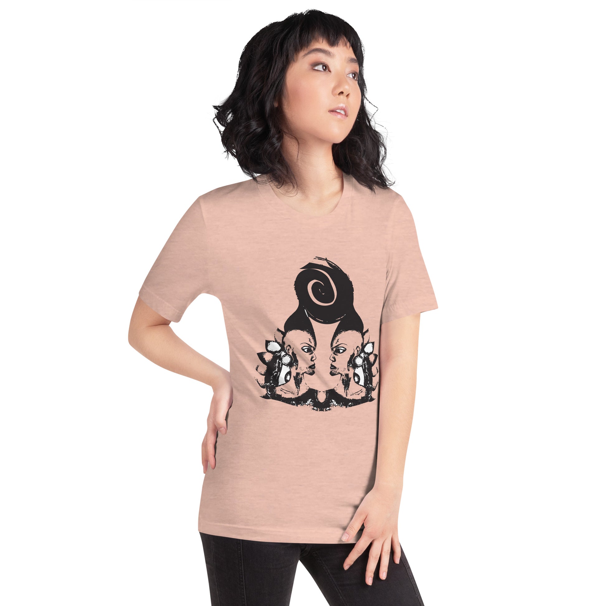 A model wearing peach color t-shirt featuring wearable illustrations with an art-inspired black design of mirrored female faces and a bold central spiral symbol, celebrating expressive fashion and individuality – unique clothing by K.L.O.E.