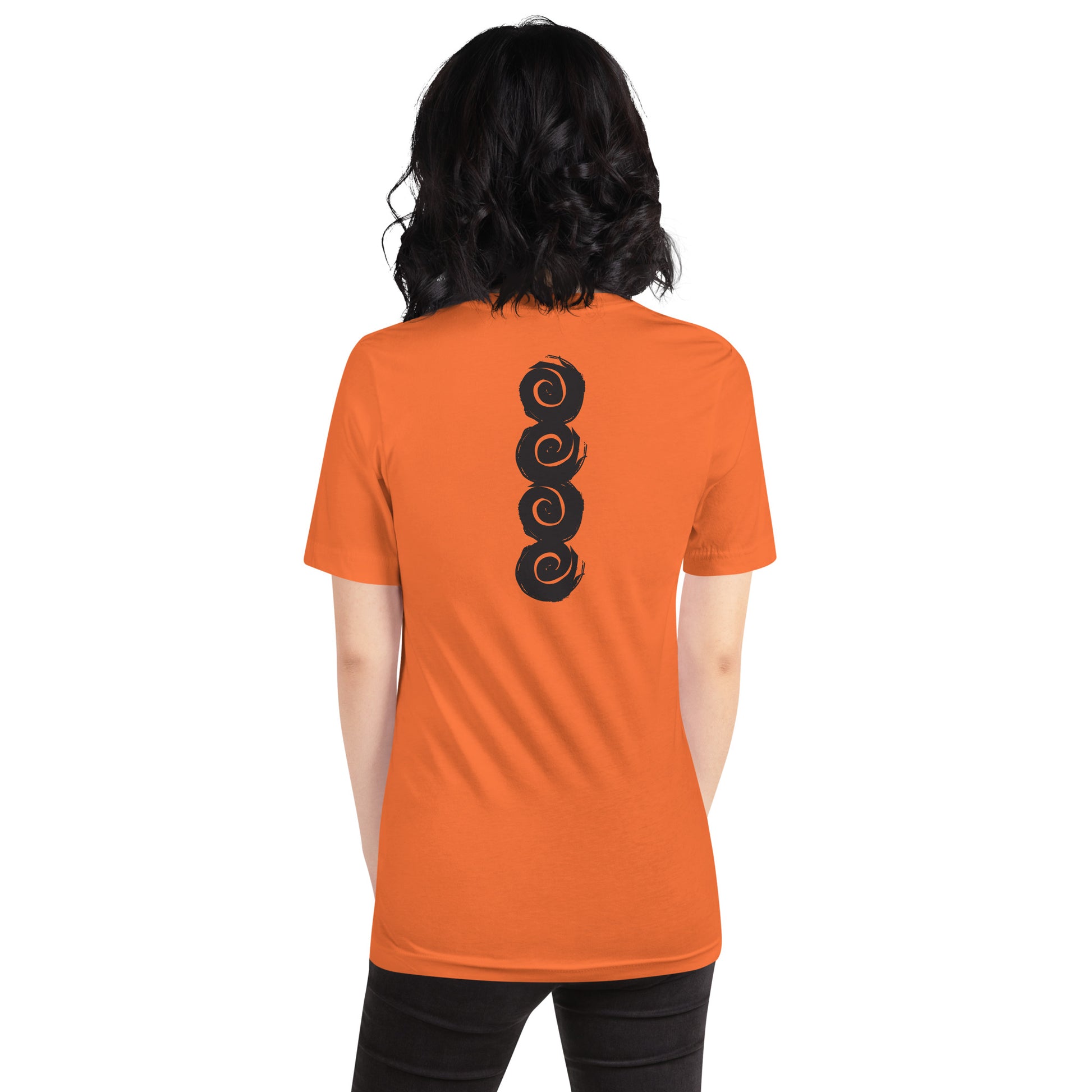 Back of an orange t-shirt featuring a vertical row of four bold, black spiral symbols, hand-drawn in an expressive, brushstroke style. This culturally inspired design from K.L.O.E. highlights artisan craftsmanship and modern boho style, perfect for those who seek unique, eco-friendly fashion and artistic self-expression, worn by a model.
