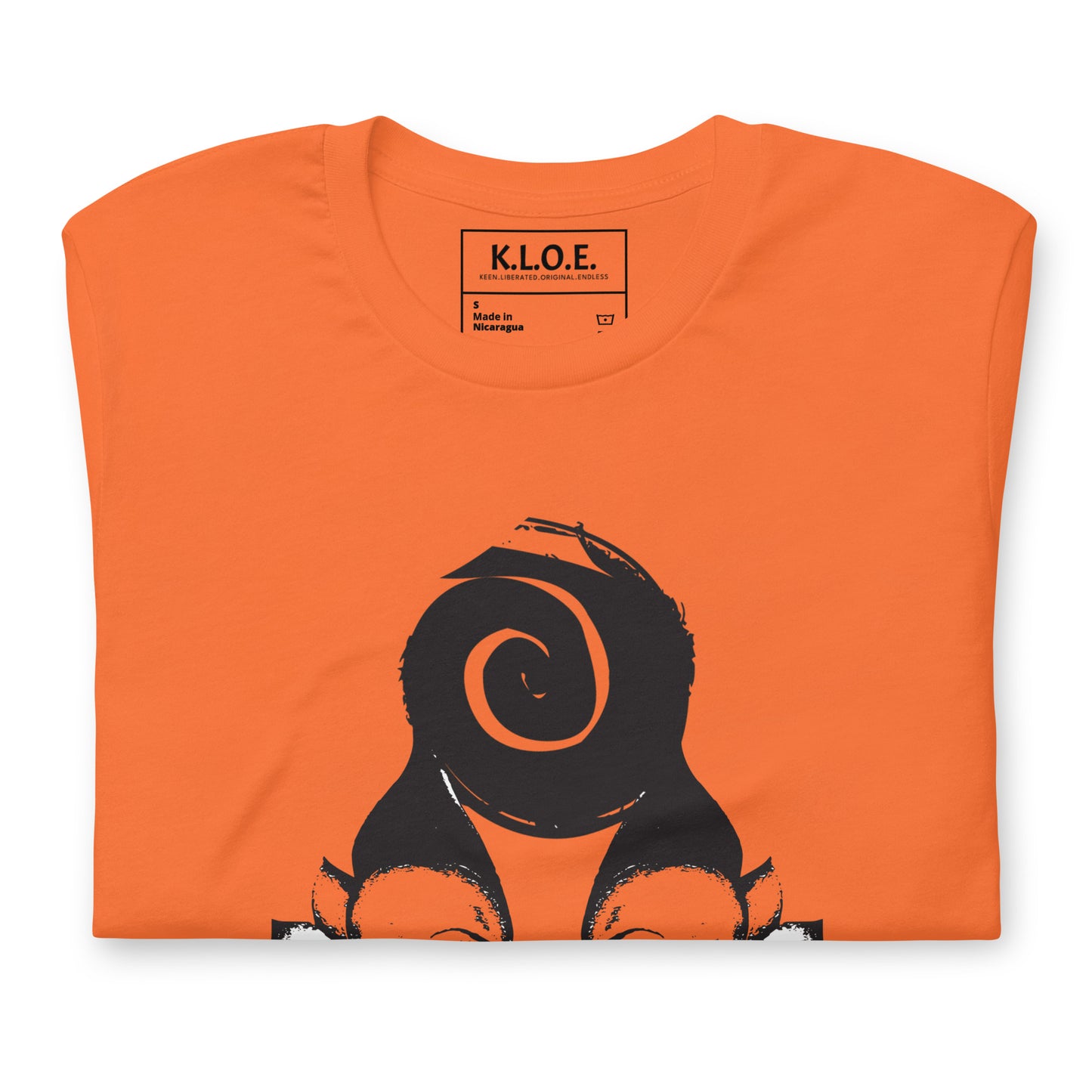 Folded orange t-shirt featuring a hand-drawn black ink design of two mirrored female figures with bold, intricate headpieces, connected by a swirling central element. This artistic piece from K.L.O.E. embraces cultural inspiration and self-expression, crafted for those who appreciate unique, expressive fashion and modern bohemian style. Detail view, showing the inside label.