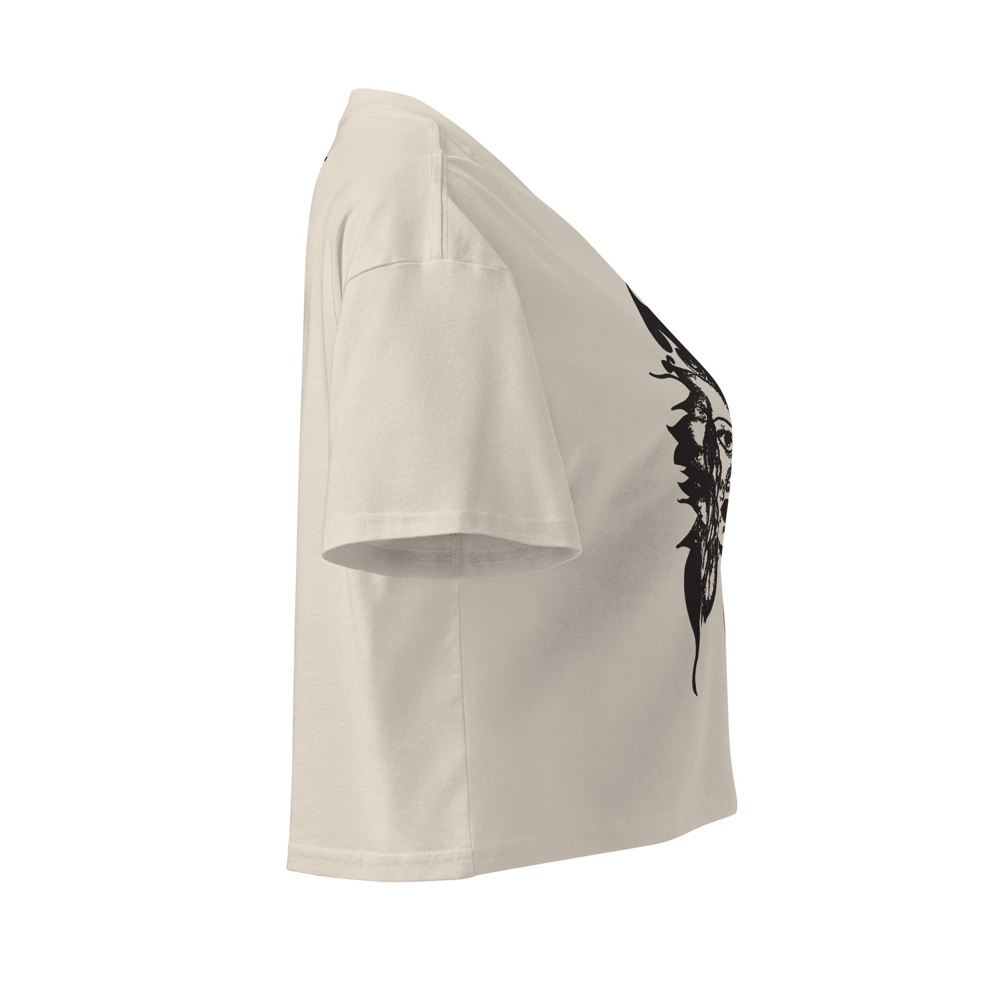 A side view of a bone K.L.O.E. crop t-shirt featuring a culturally inspired, hand-drawn black graphic of a bold, expressive face surrounded by intricate details, celebrating individuality and artistic self-expression in modern bohemian style fashion.