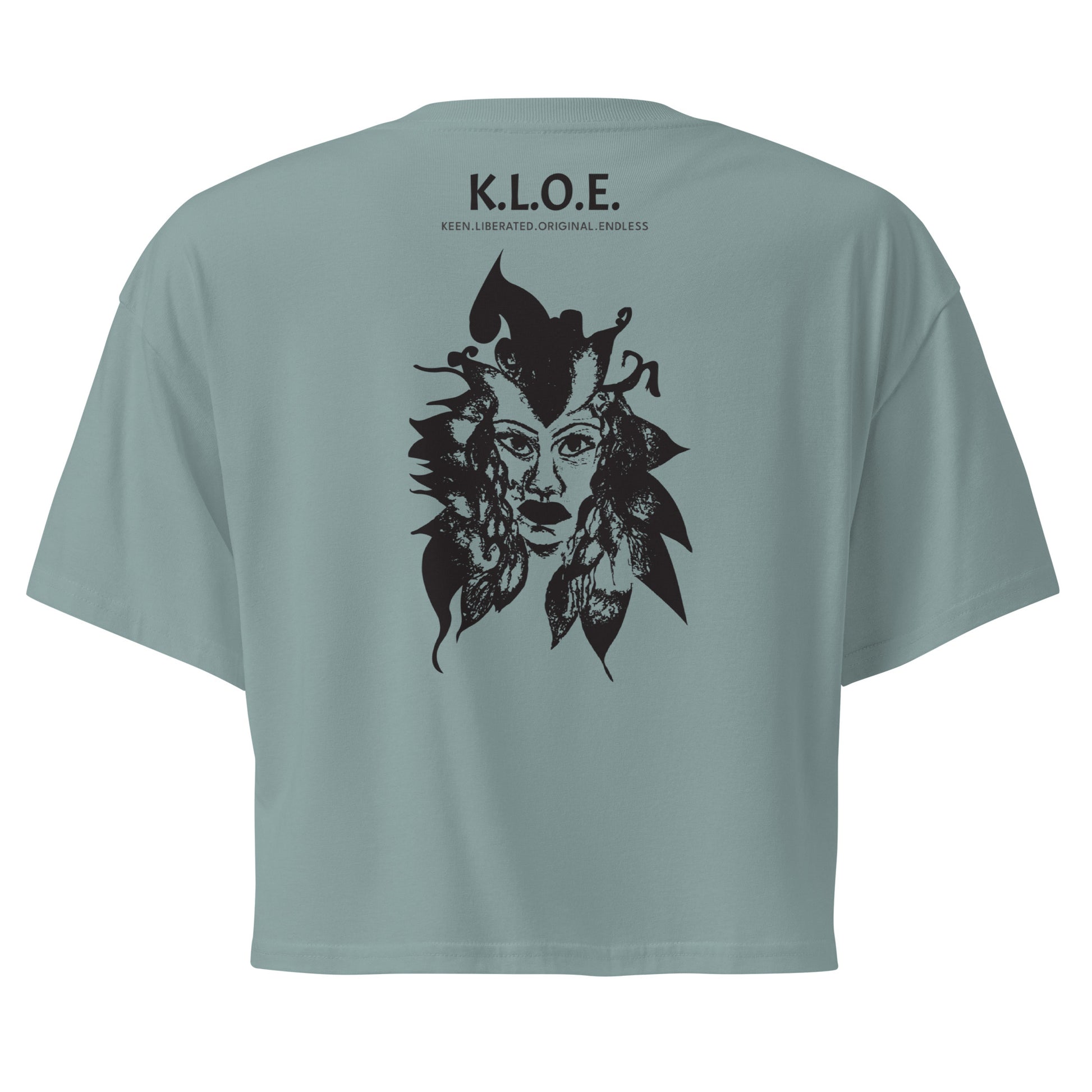 Back view of a mineral K.L.O.E. crop t-shirt showcasing a culturally inspired, hand-drawn black design featuring a bold, expressive face intertwined with flowing, abstract patterns, and K.L.O.E. logo, embodying artistic self-expression and modern bohemian style fashion.