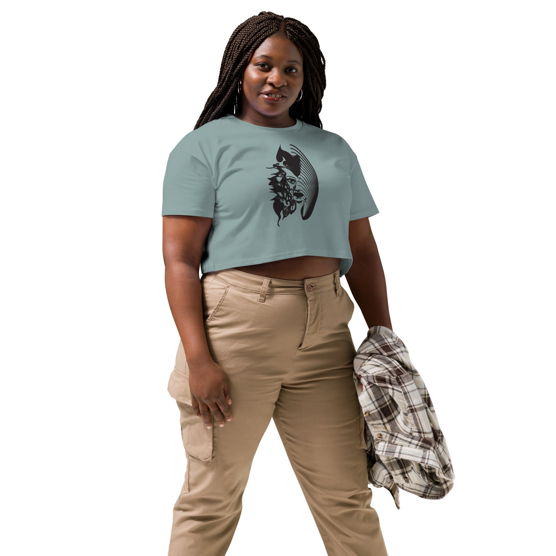 A model wearing a mineral K.L.O.E. crop t-shirt featuring a culturally inspired, hand-drawn black graphic of a bold, expressive face surrounded by intricate details, celebrating individuality and artistic self-expression in modern bohemian style fashion.