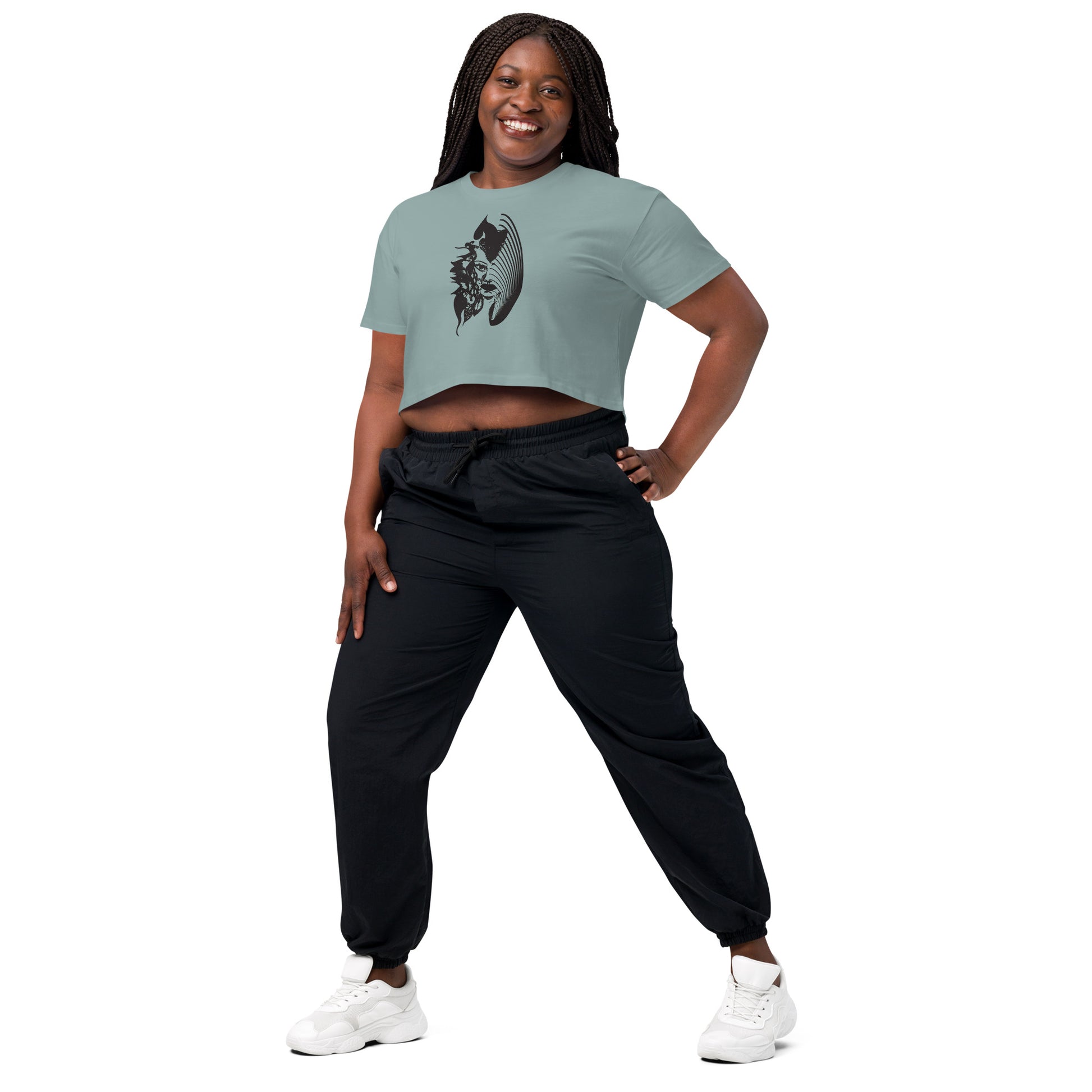 A model wearing a mineral K.L.O.E. crop t-shirt featuring a culturally inspired, hand-drawn black graphic of a bold, expressive face surrounded by intricate details, celebrating individuality and artistic self-expression in modern bohemian style fashion.