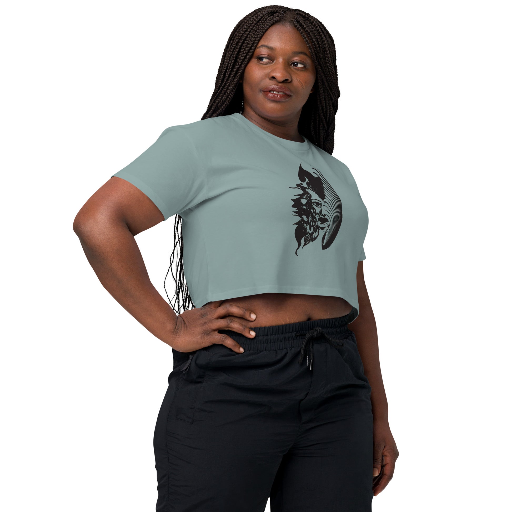 A model wearing a mineral K.L.O.E. crop t-shirt featuring a culturally inspired, hand-drawn black graphic of a bold, expressive face surrounded by intricate details, celebrating individuality and artistic self-expression in modern bohemian style fashion.