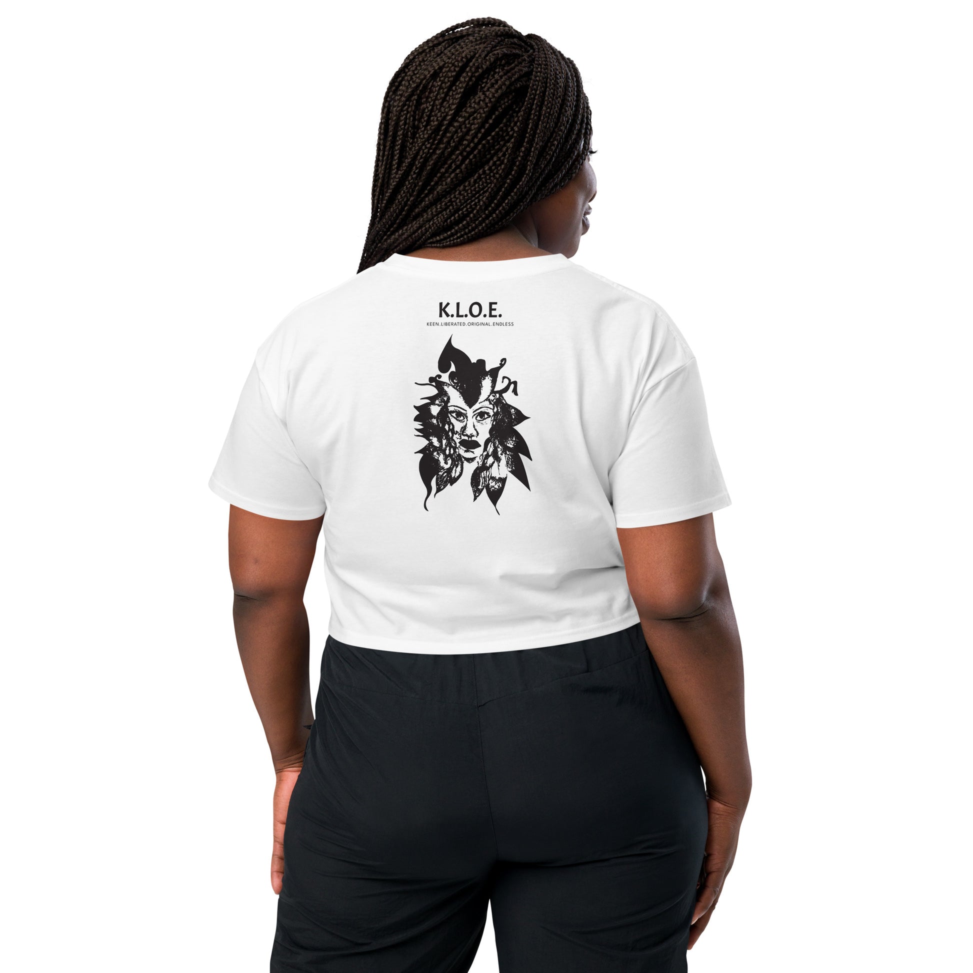 Back view of a white K.L.O.E. crop t-shirt showcasing a culturally inspired, hand-drawn black design featuring a bold, expressive face intertwined with flowing, abstract patterns, and K.L.O.E. logo, embodying artistic self-expression and modern bohemian style fashion, on a model.