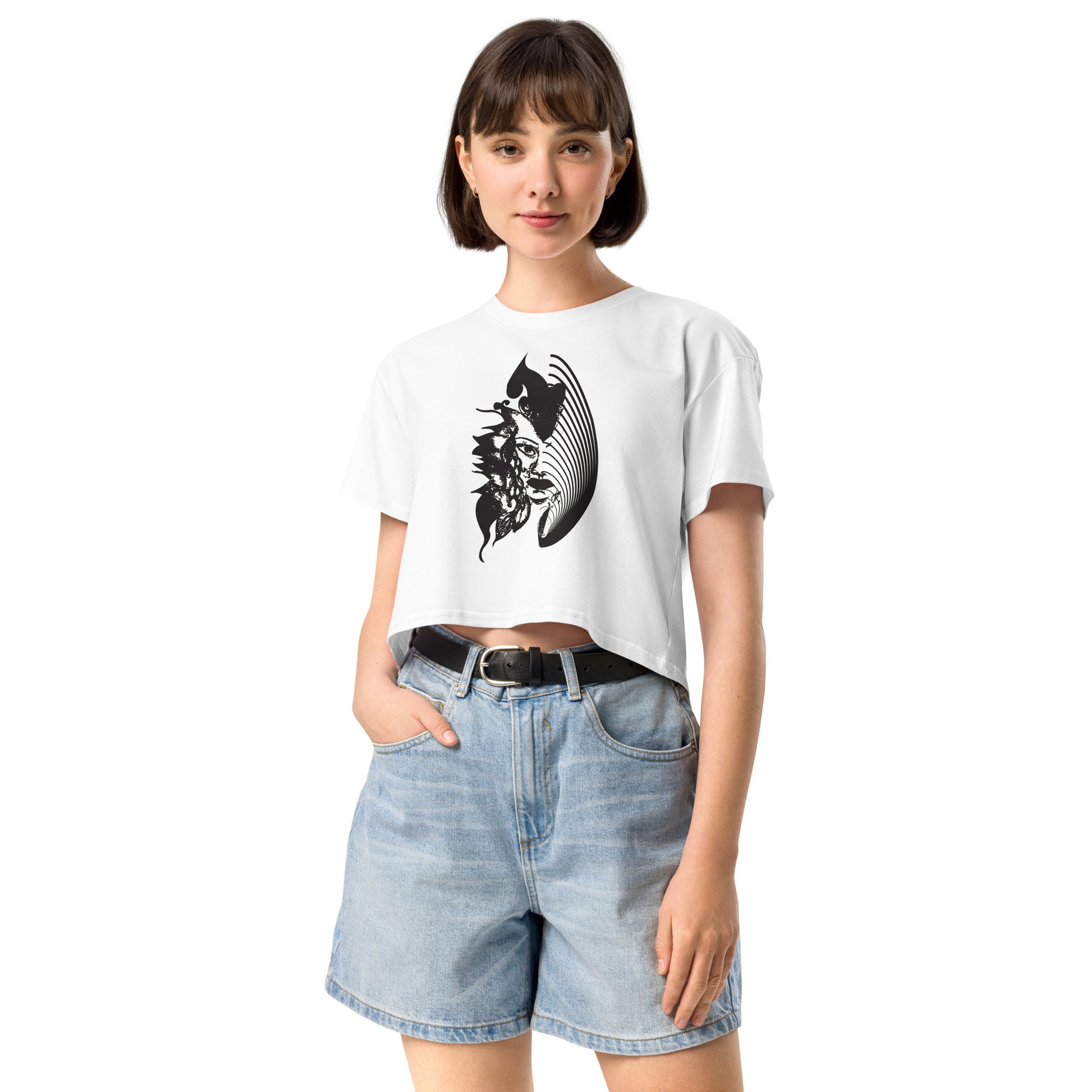 A model wearing white K.L.O.E. crop t-shirt featuring a culturally inspired, hand-drawn black graphic of a bold, expressive face surrounded by intricate details, celebrating individuality and artistic self-expression in modern bohemian style fashion.