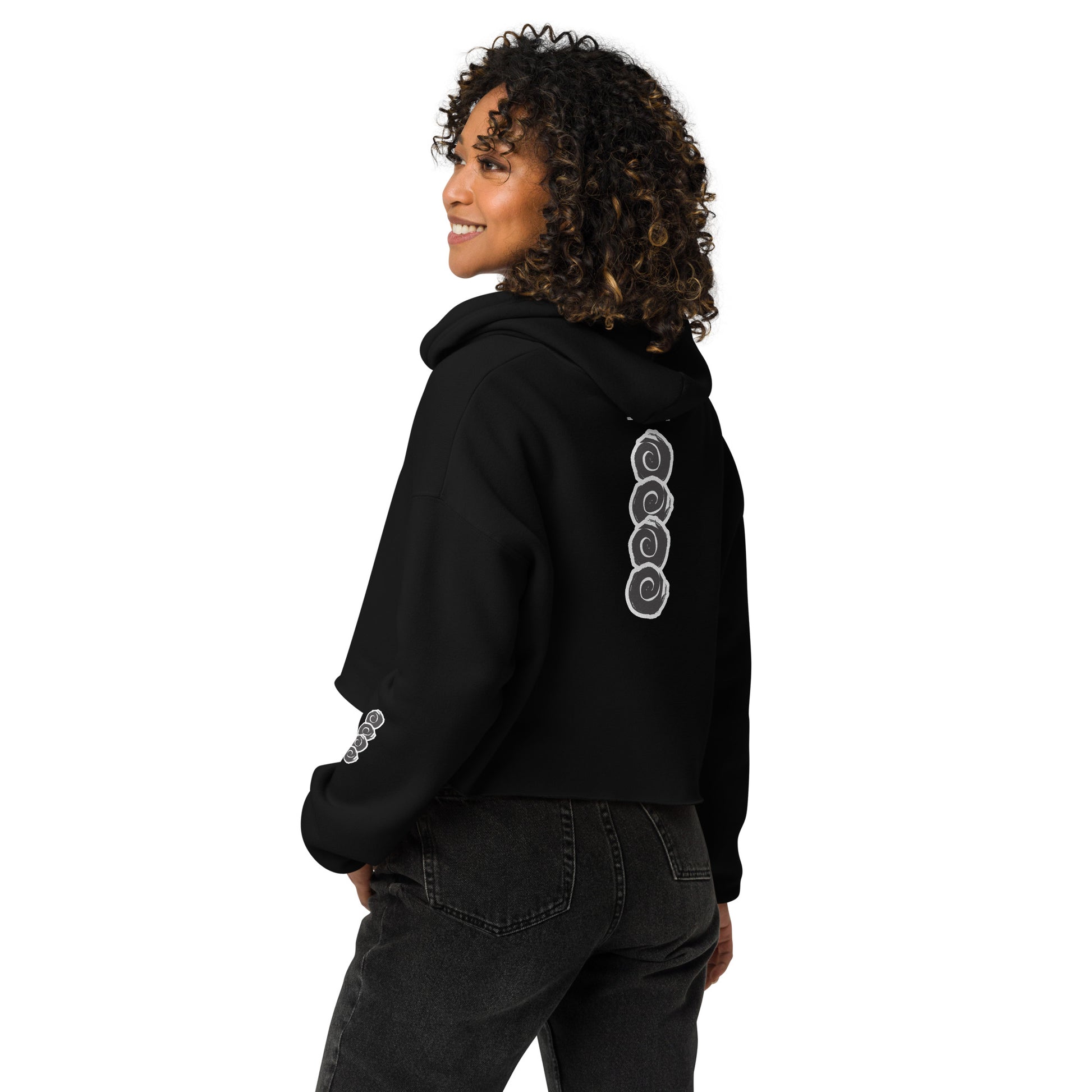 Back view of a black cropped hoodie featuring a vertical row of three hand-drawn white spirals in a bold, brushstroke style. This unique, culturally inspired design from K.L.O.E. embodies modern boho style and artistic expression, ideal for those seeking eco-friendly, artisan fashion with a contemporary edge.