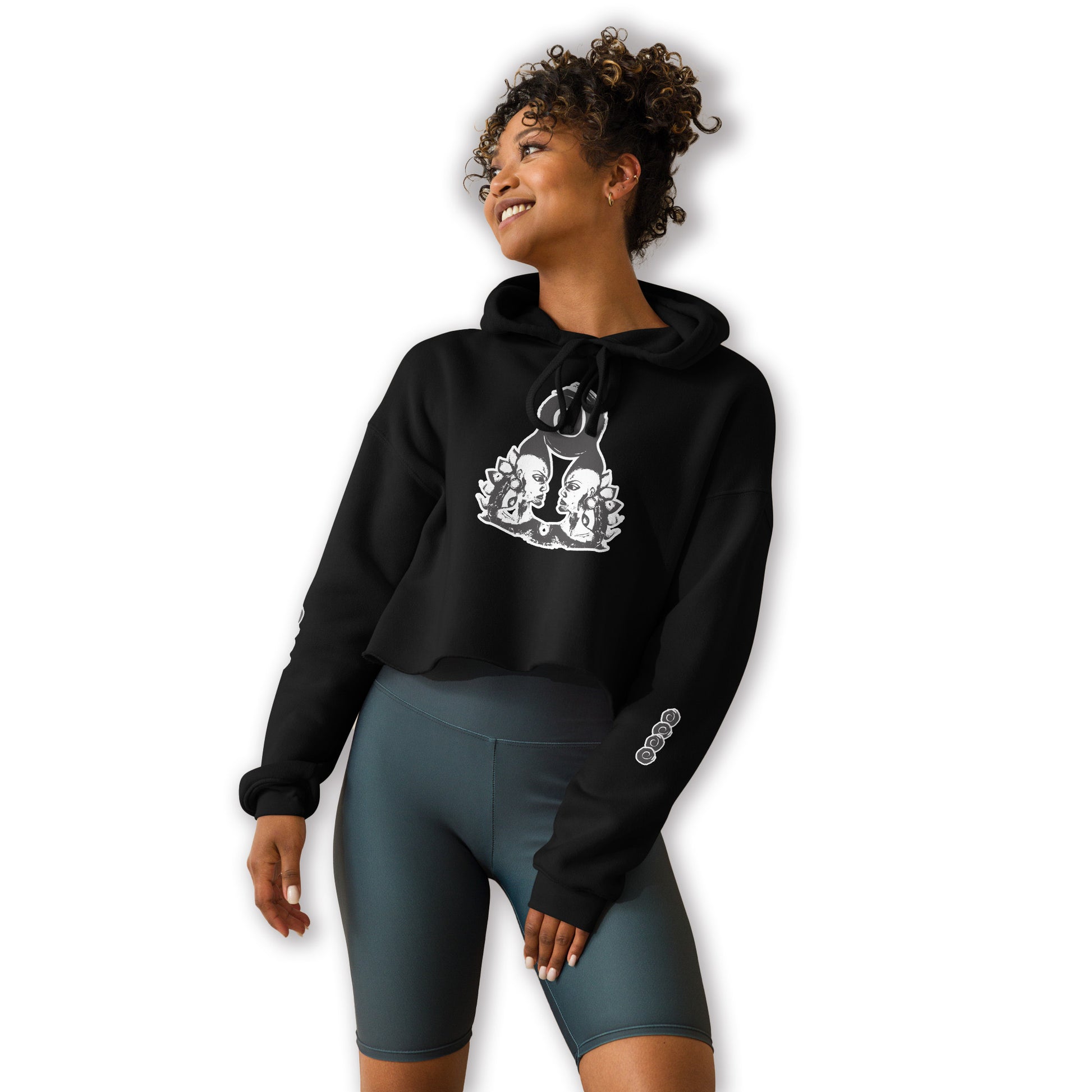 Black cropped hoodie featuring a white, hand-drawn graphic of two mirrored female figures with bold, intricate headpieces and a swirling central element. This culturally inspired, artisan design from K.L.O.E. captures modern boho style and expressive fashion, perfect for individuals seeking unique, eco-friendly apparel that celebrates self-expression and global artistry.